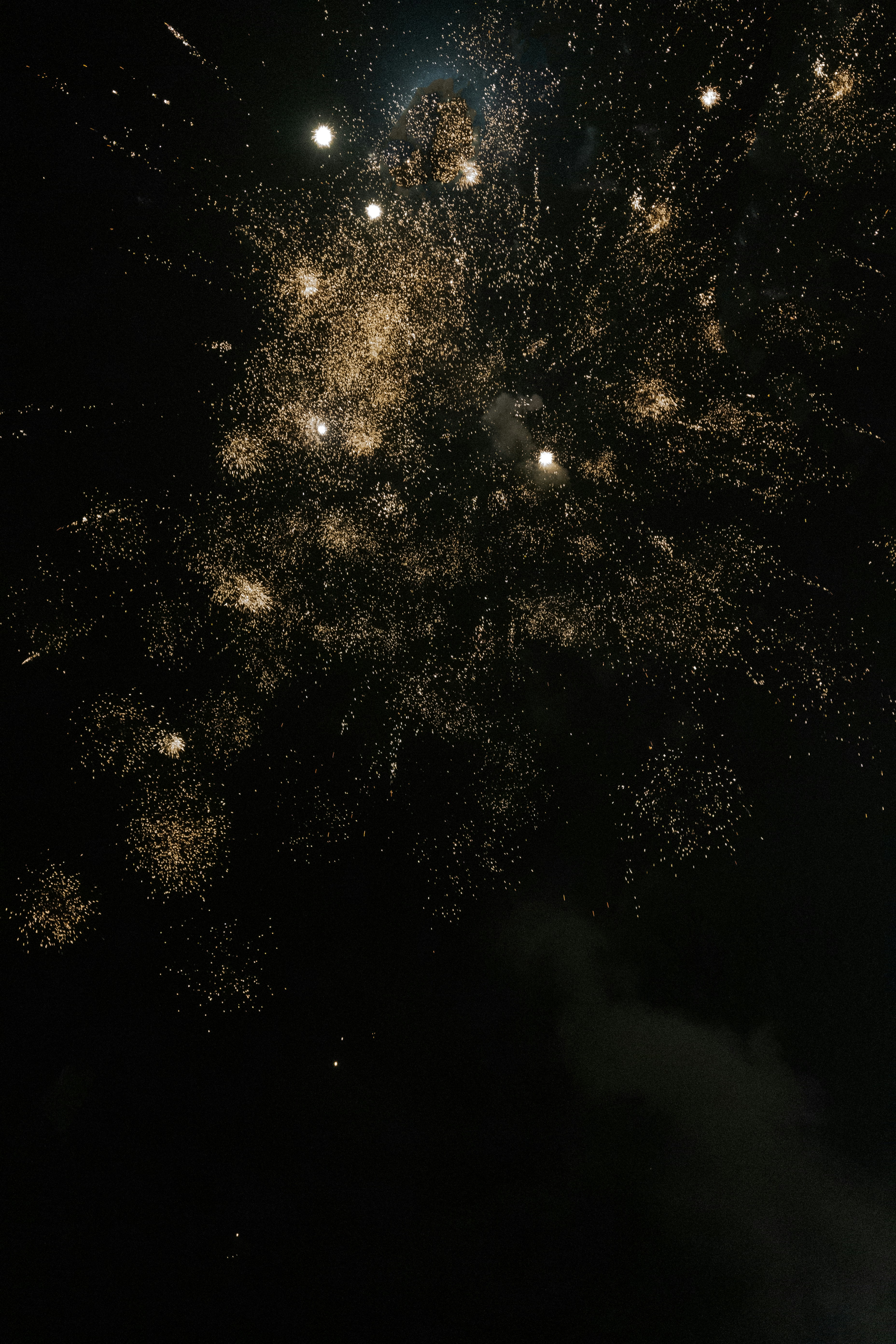 Golden fireworks exploding in the night sky