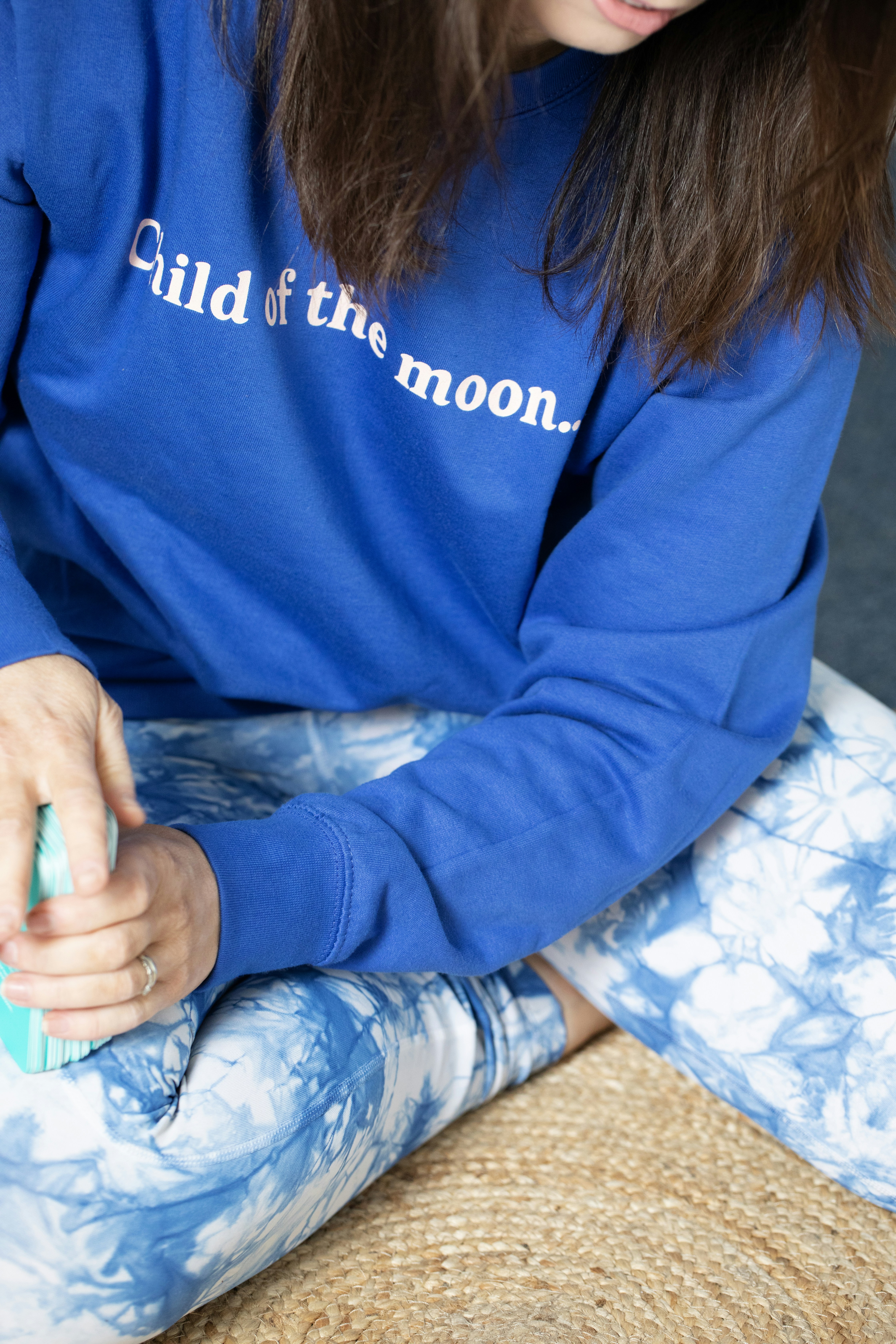 Woman in blue sweatshirt and tie-dye pants