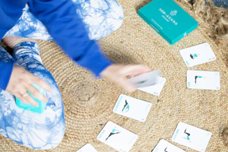 Person playing yoga cards on a mat.