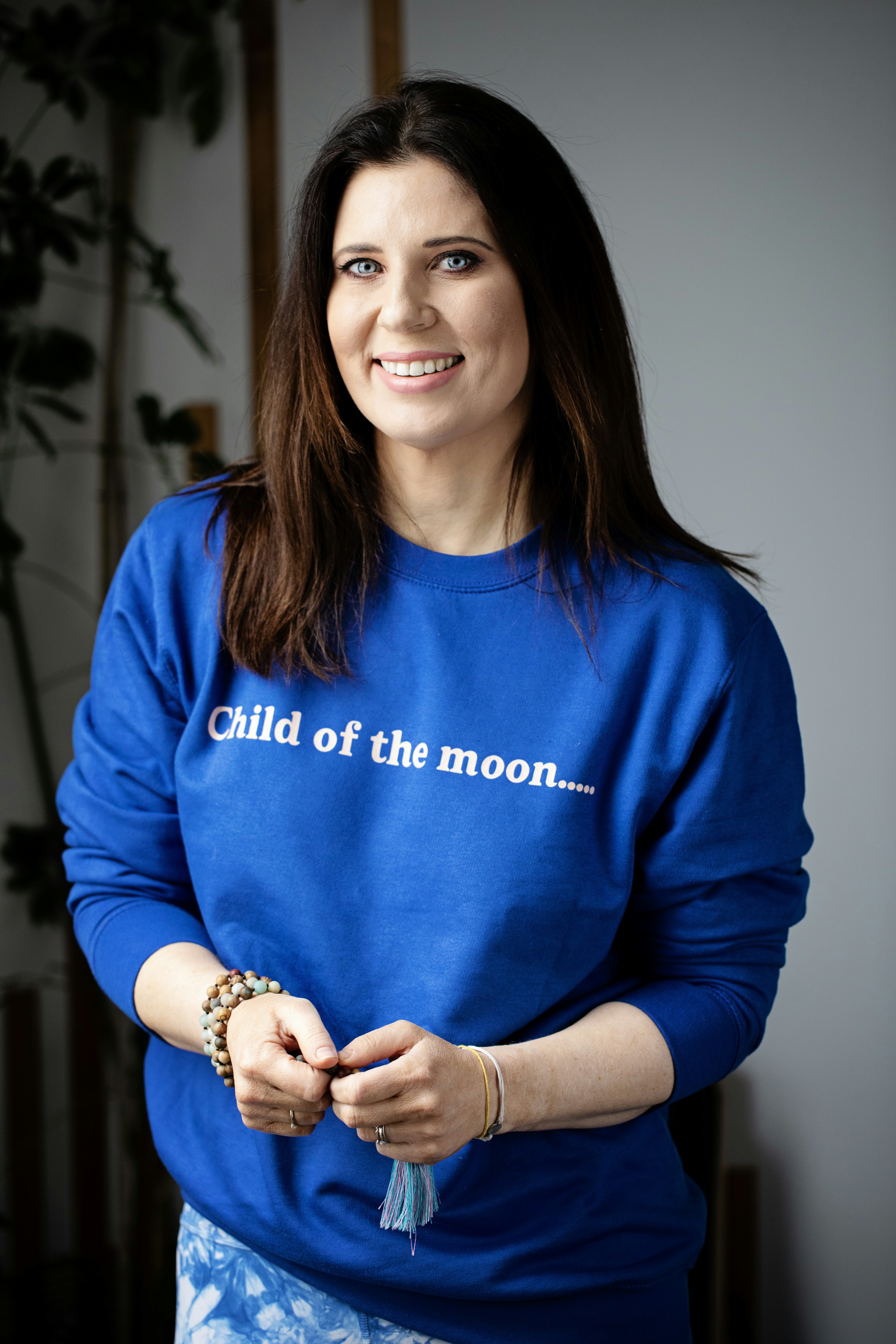 Woman in blue sweatshirt with text smiles