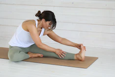 Woman stretching on a yoga mat indoors.