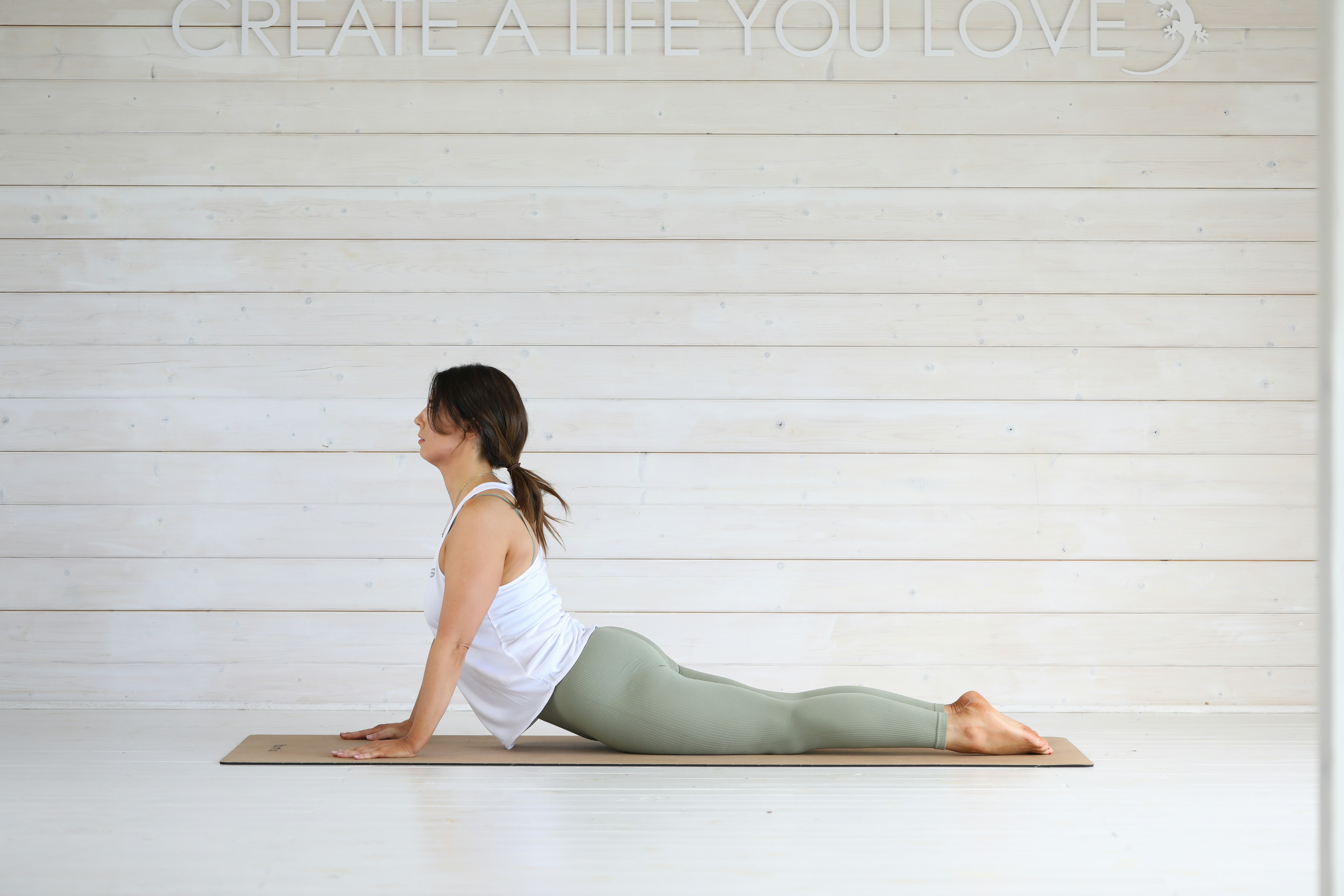 Woman doing cobra pose on yoga mat
