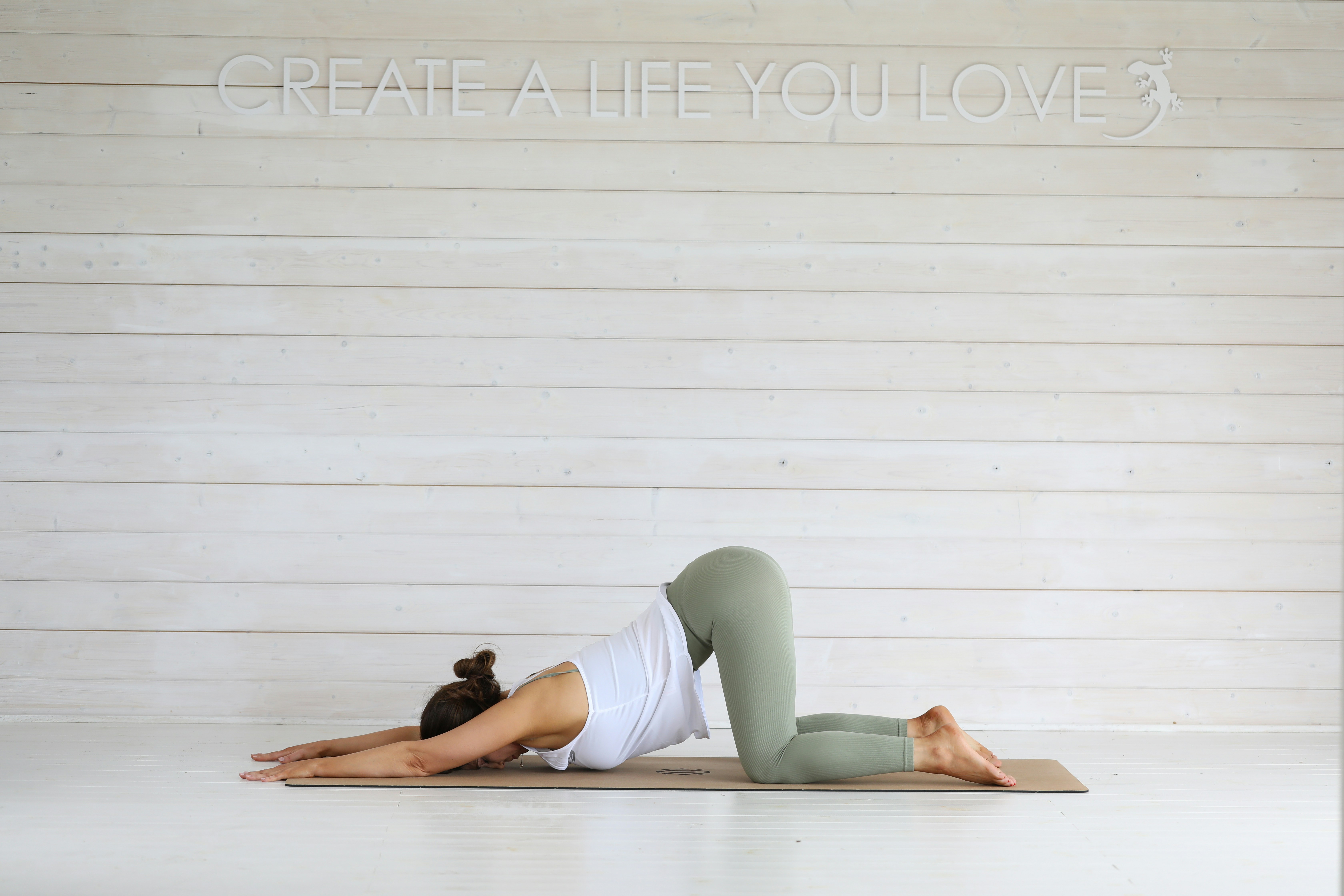 Frau übt Yoga-Kinderpose auf der Matte