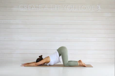 Woman practicing yoga child's pose on mat