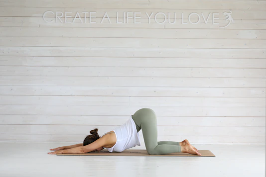 Woman practicing yoga child's pose on mat