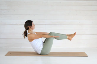 Woman doing yoga boat pose on mat