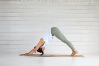 Woman in downward dog yoga pose on mat.