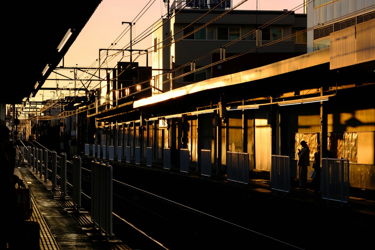 ชานชาลาในยามพลบค่ำ มีไฟโทนอุ่นเรียงรายตลอดแนว