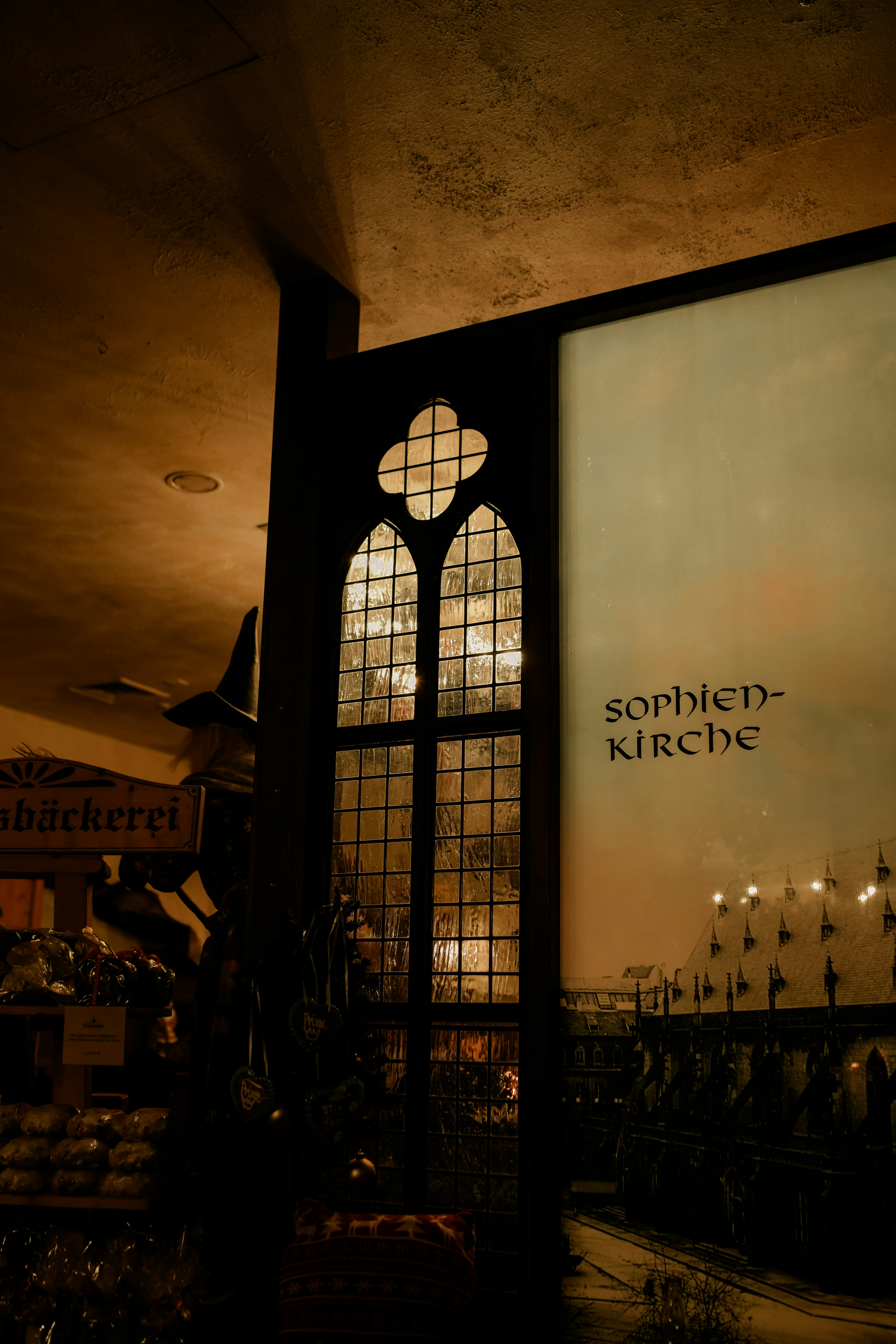 Gothic window with ornate tracery and text.