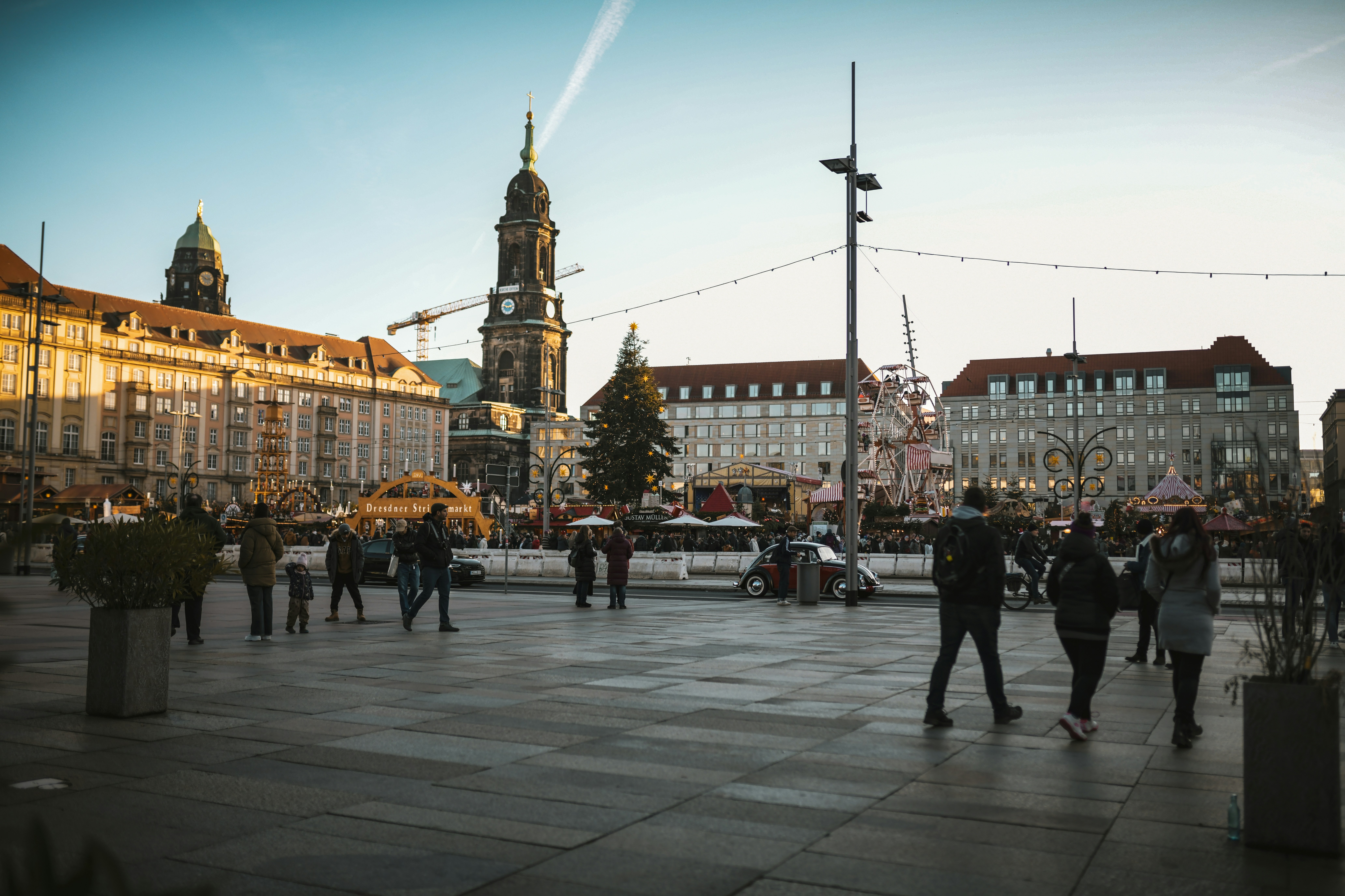 People walking in a european city square at dusk.