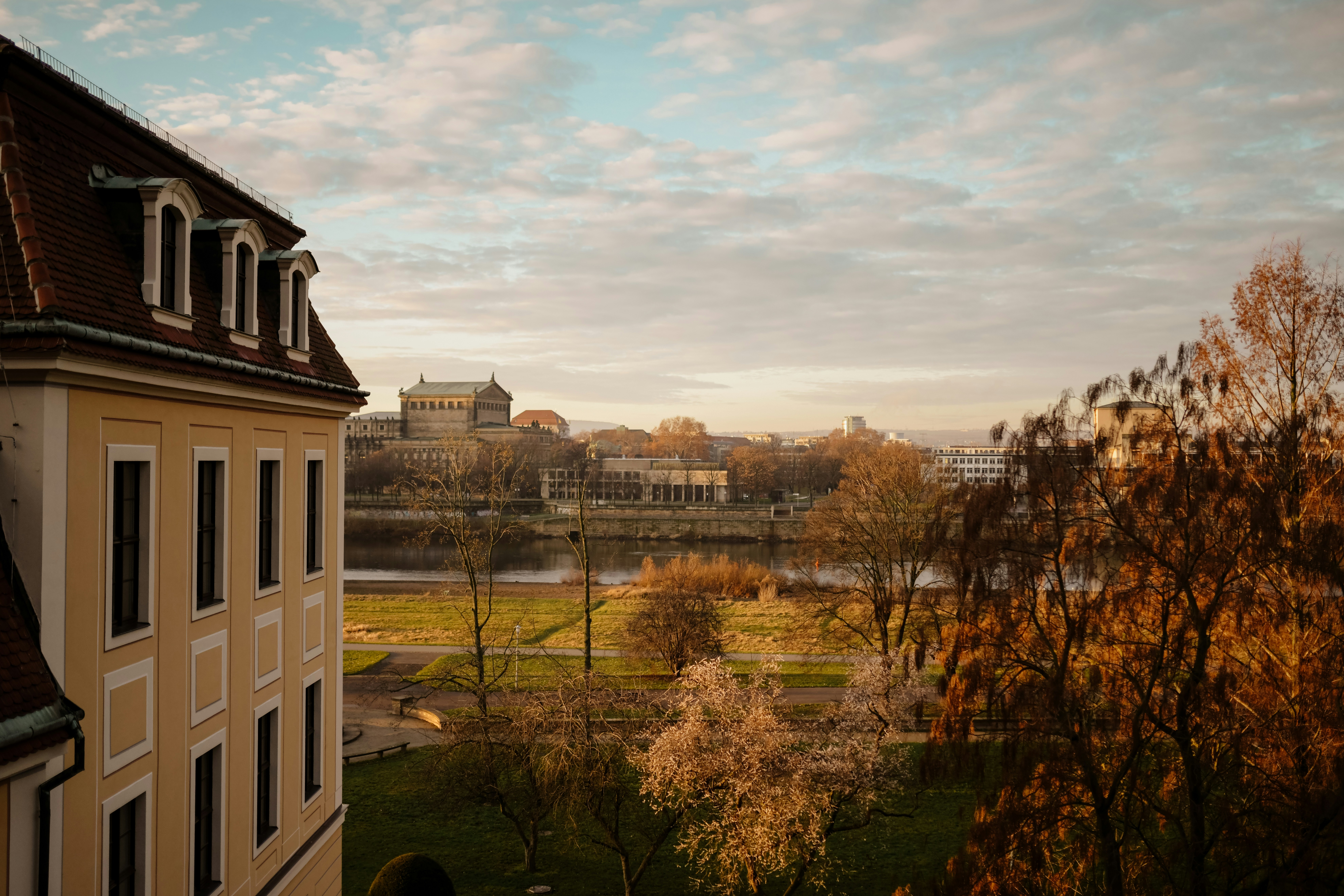 Building facade with autumn trees and river view.