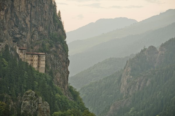 Monastery built into a steep, forested mountain cliff — Orheiul Vechi, Moldova