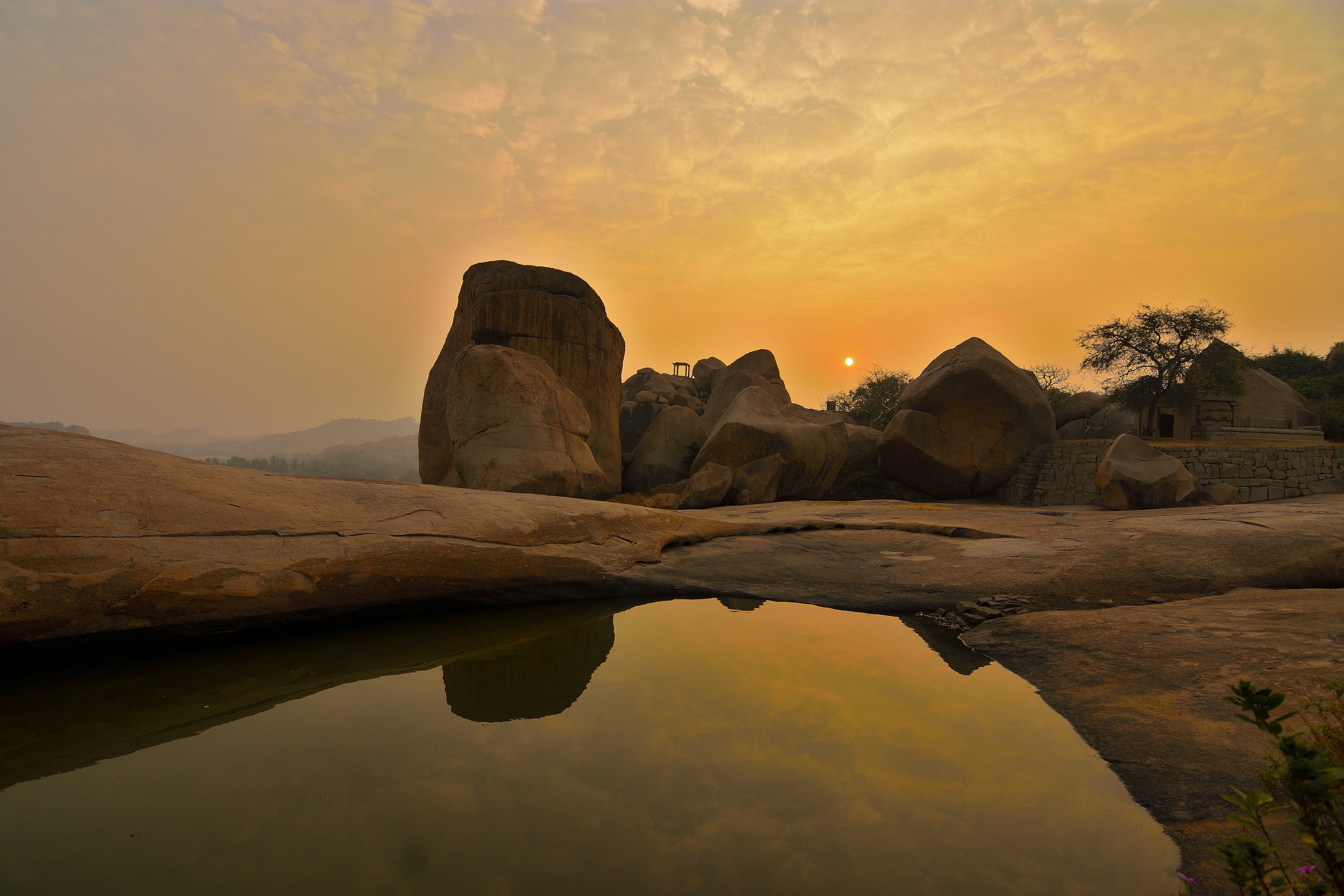 Rocky landscape with a small pond at sunset