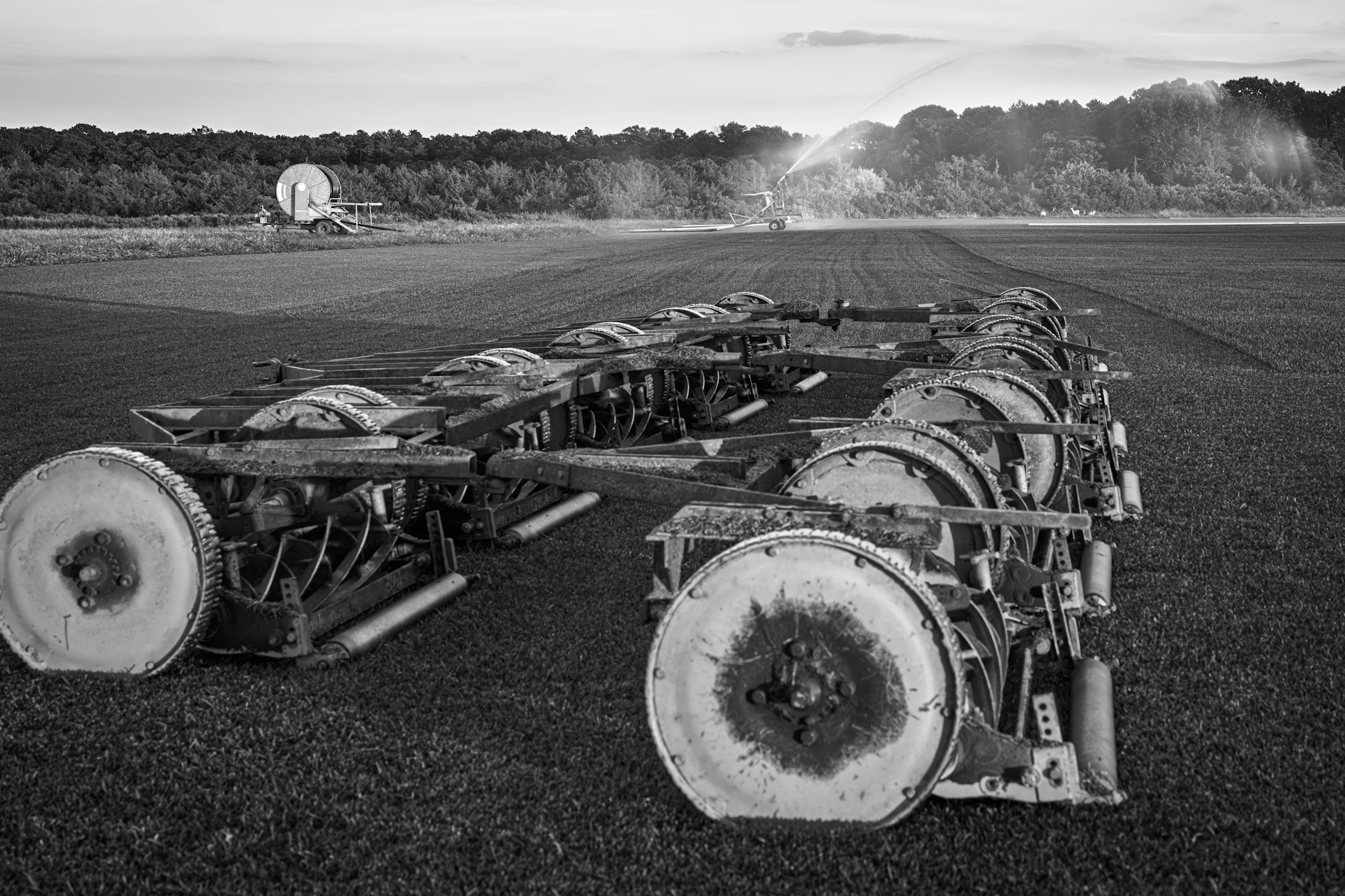 Agricultural machinery in a field with sprinklers.