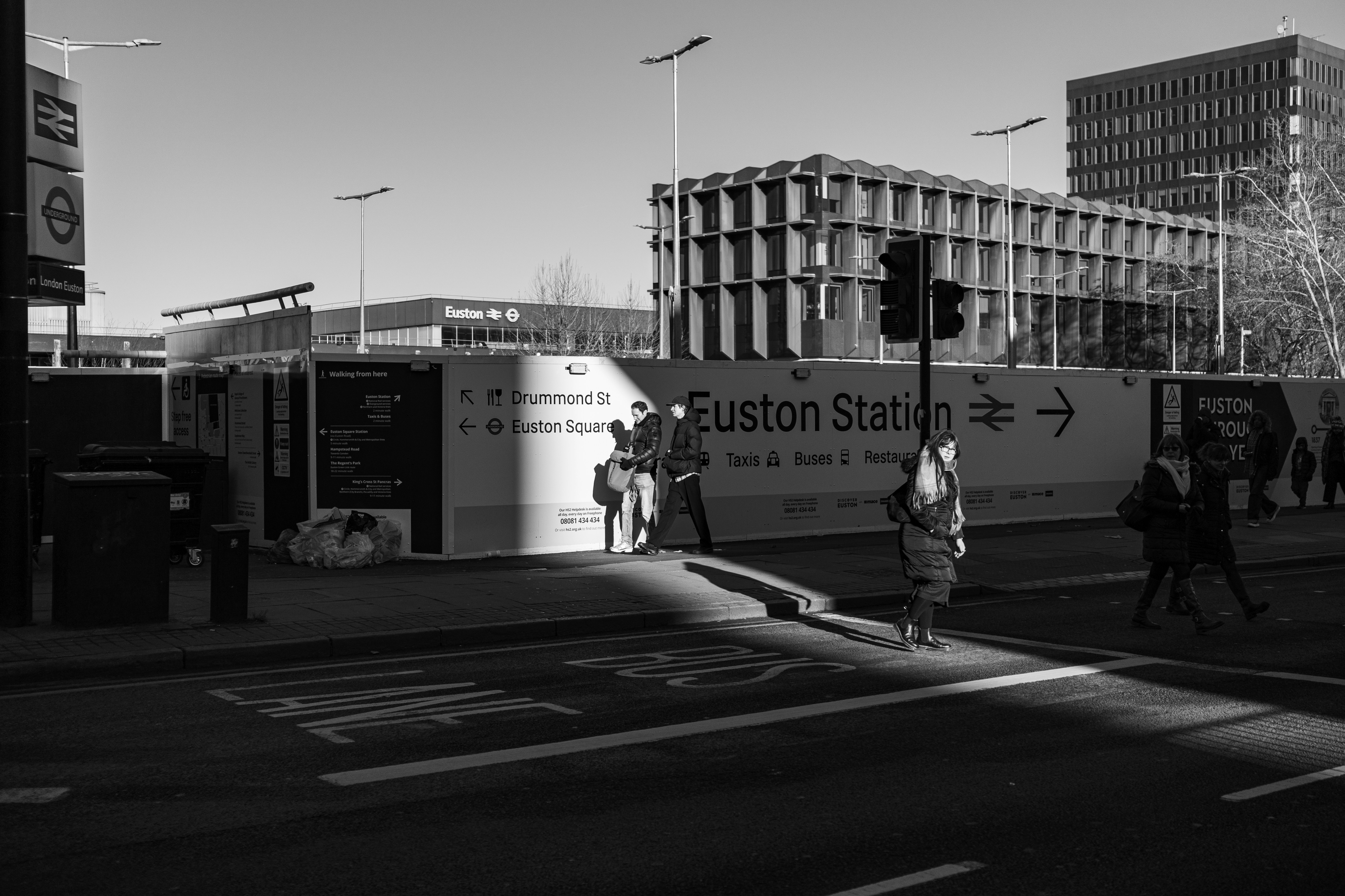 People walk past euston station construction site.