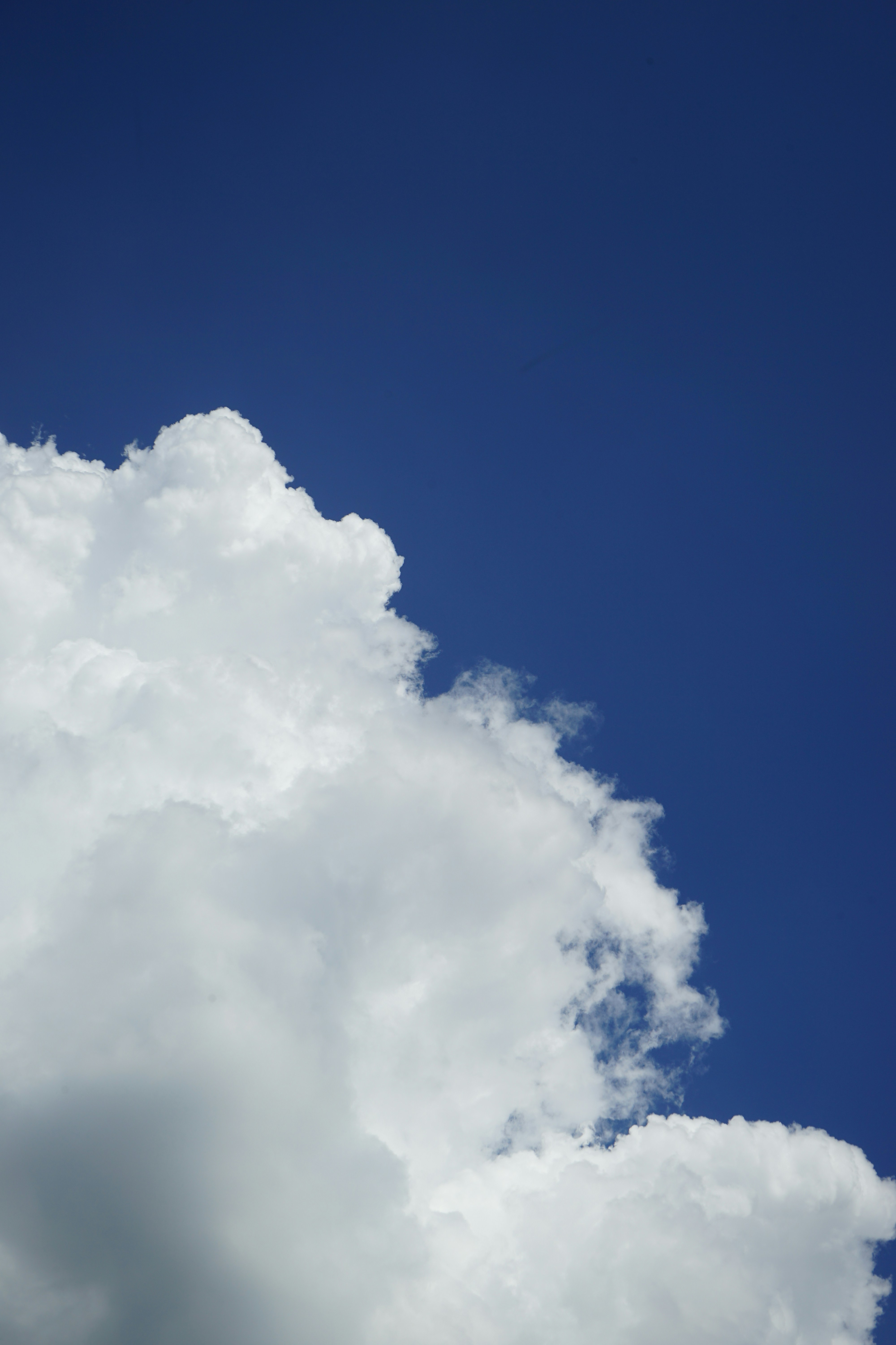 Fluffy white clouds against a vibrant blue sky