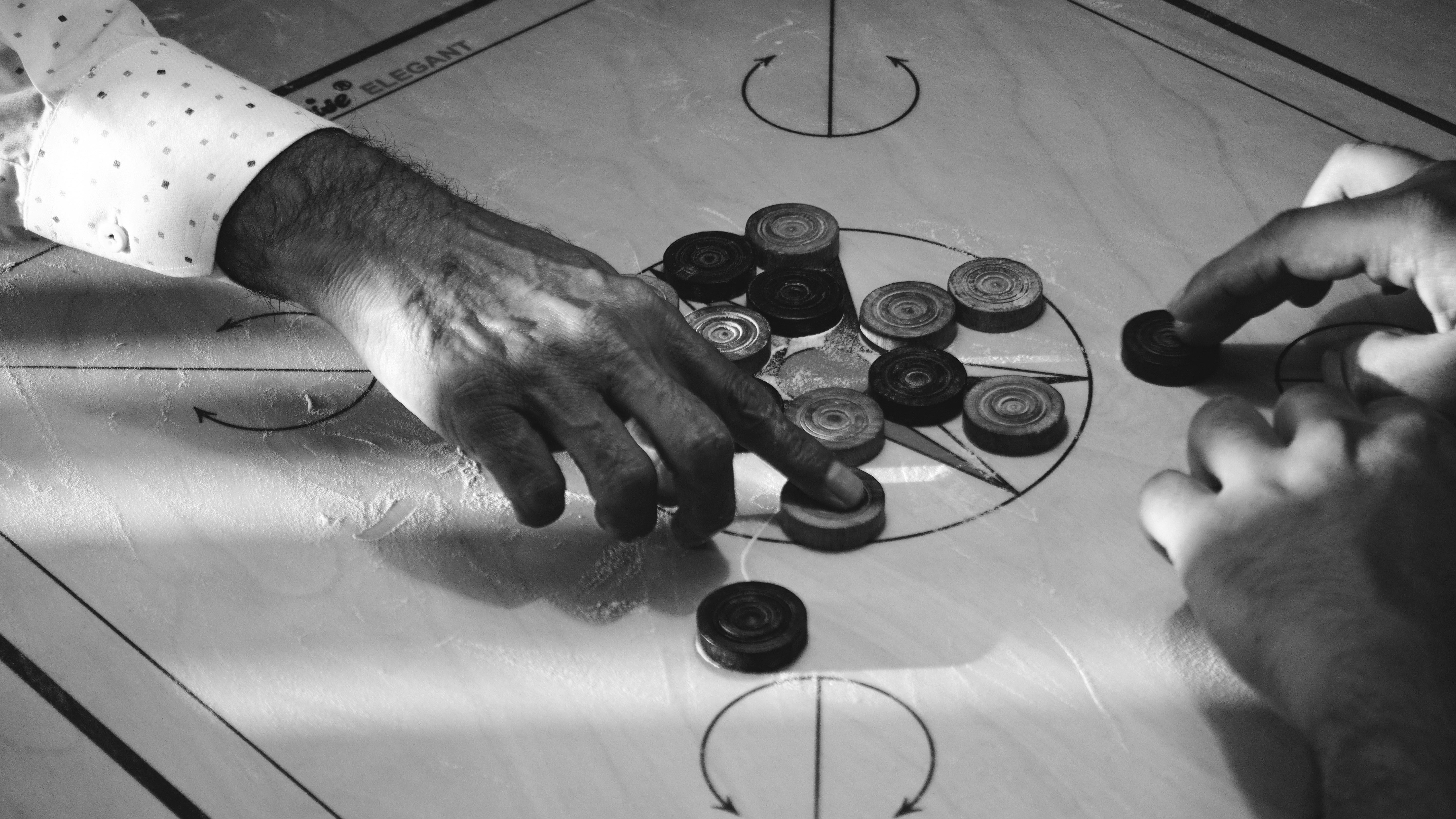 Two people playing carrom board game