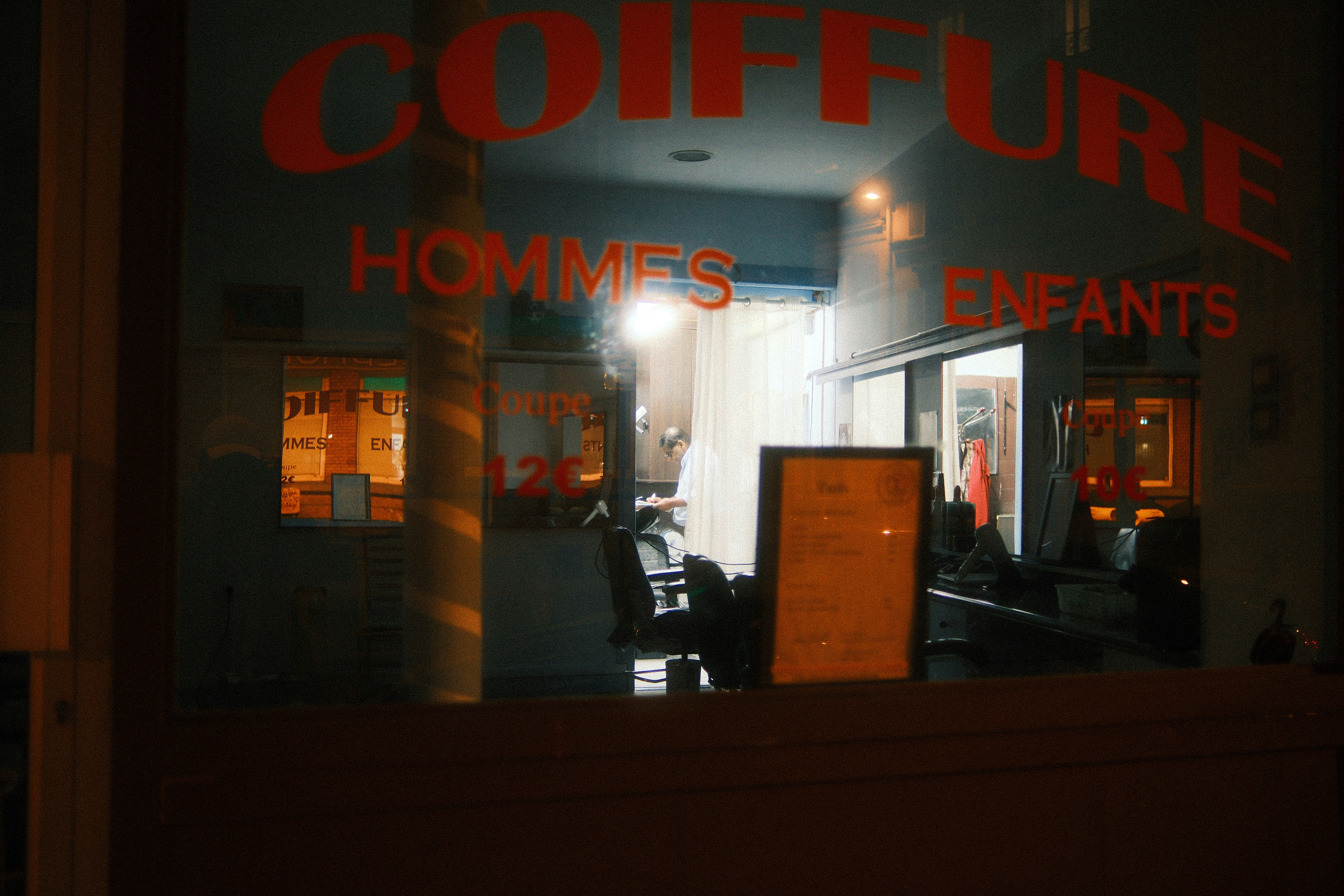 Friseursalon nachts mit "Coiffure"-Schild