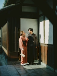 Couple in traditional kimonos standing outside building