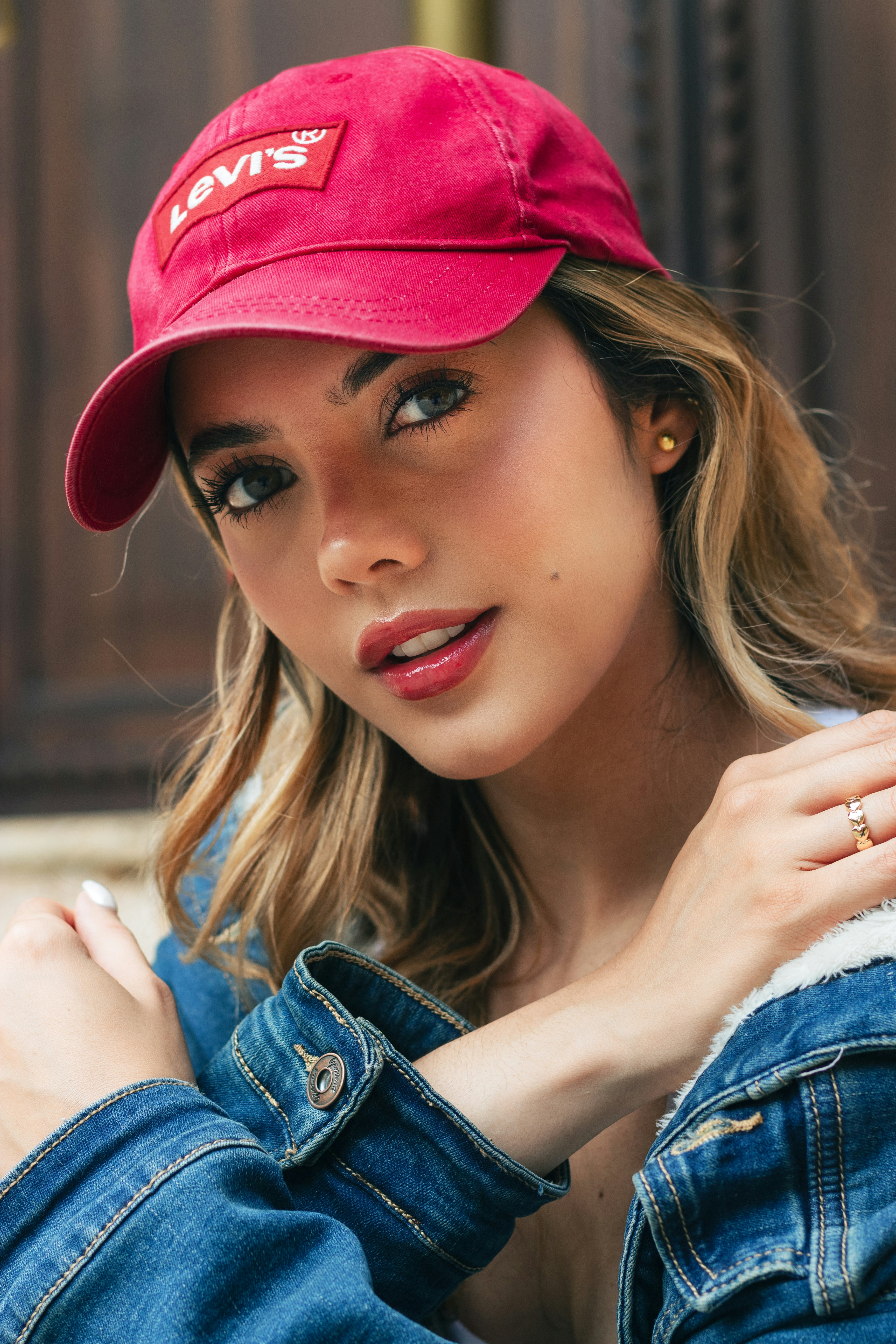 Young woman wearing a red cap and denim jacket