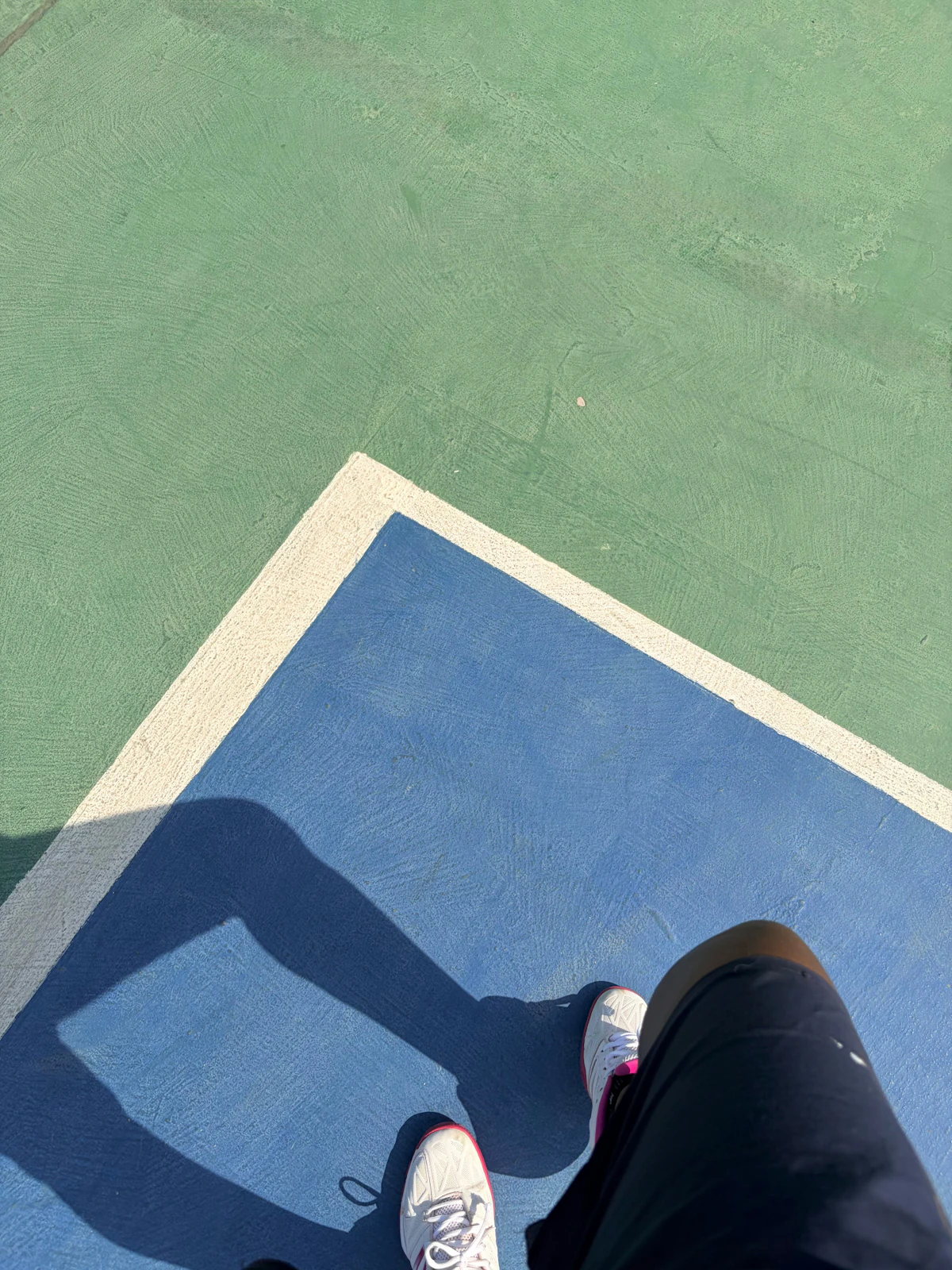 Court shoes on a blue and green outdoor hard court