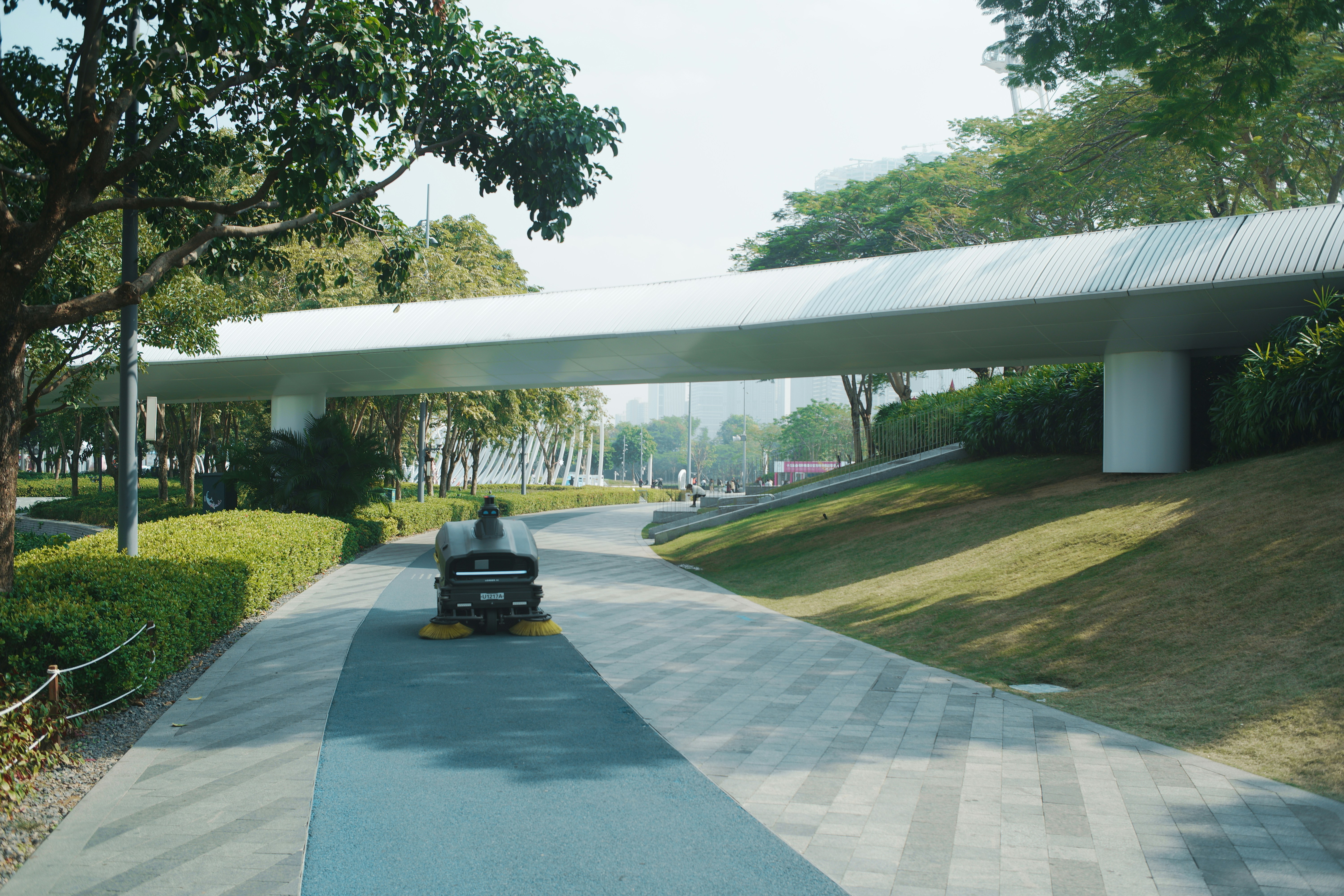 Modern pedestrian bridge over a park pathway