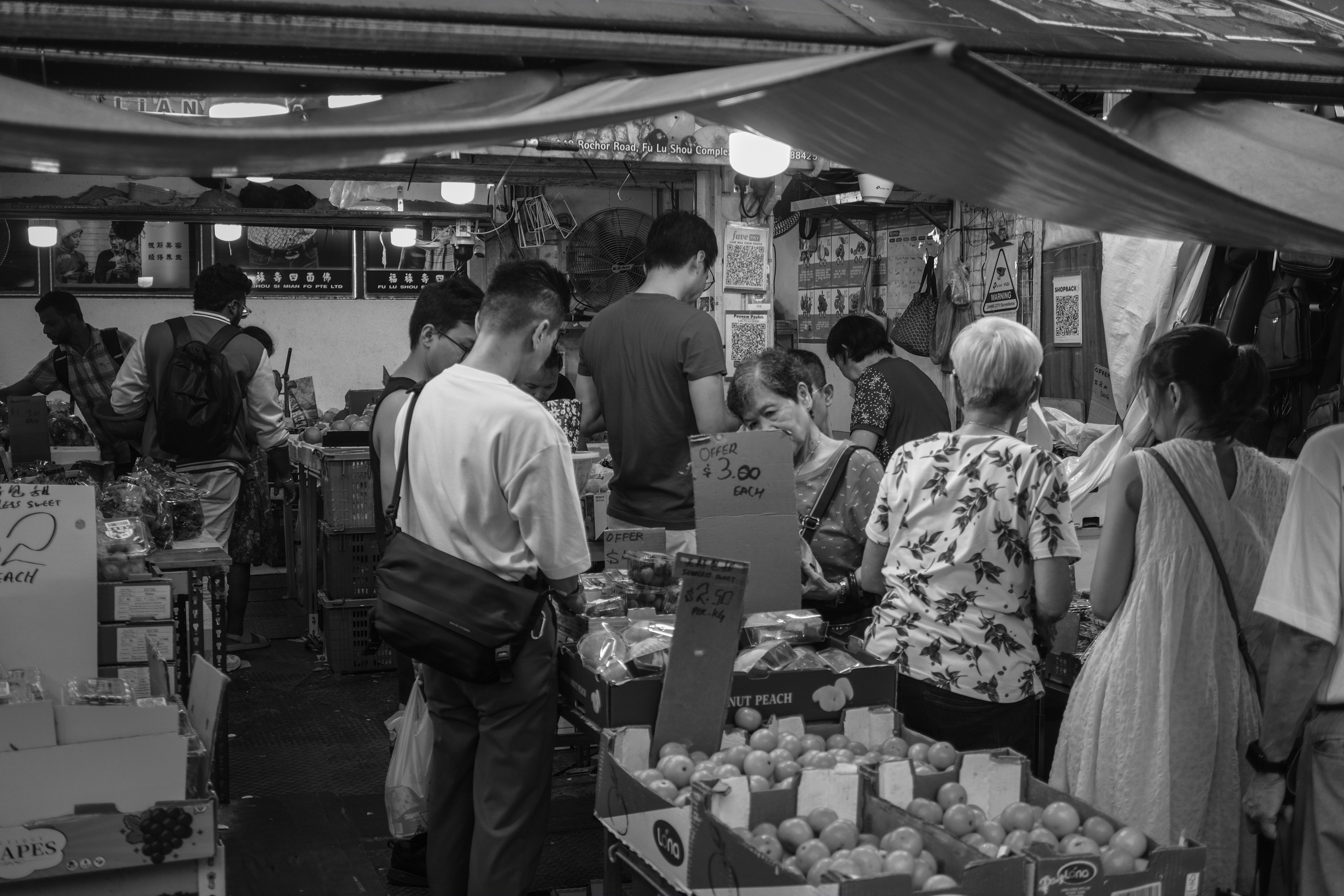 People browsing stalls at a busy outdoor market.