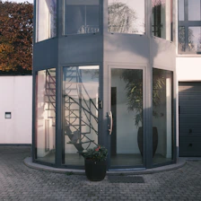 Modern glass entryway with spiral staircase inside