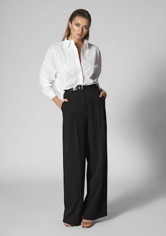 Woman in white shirt and black wide-leg pants.