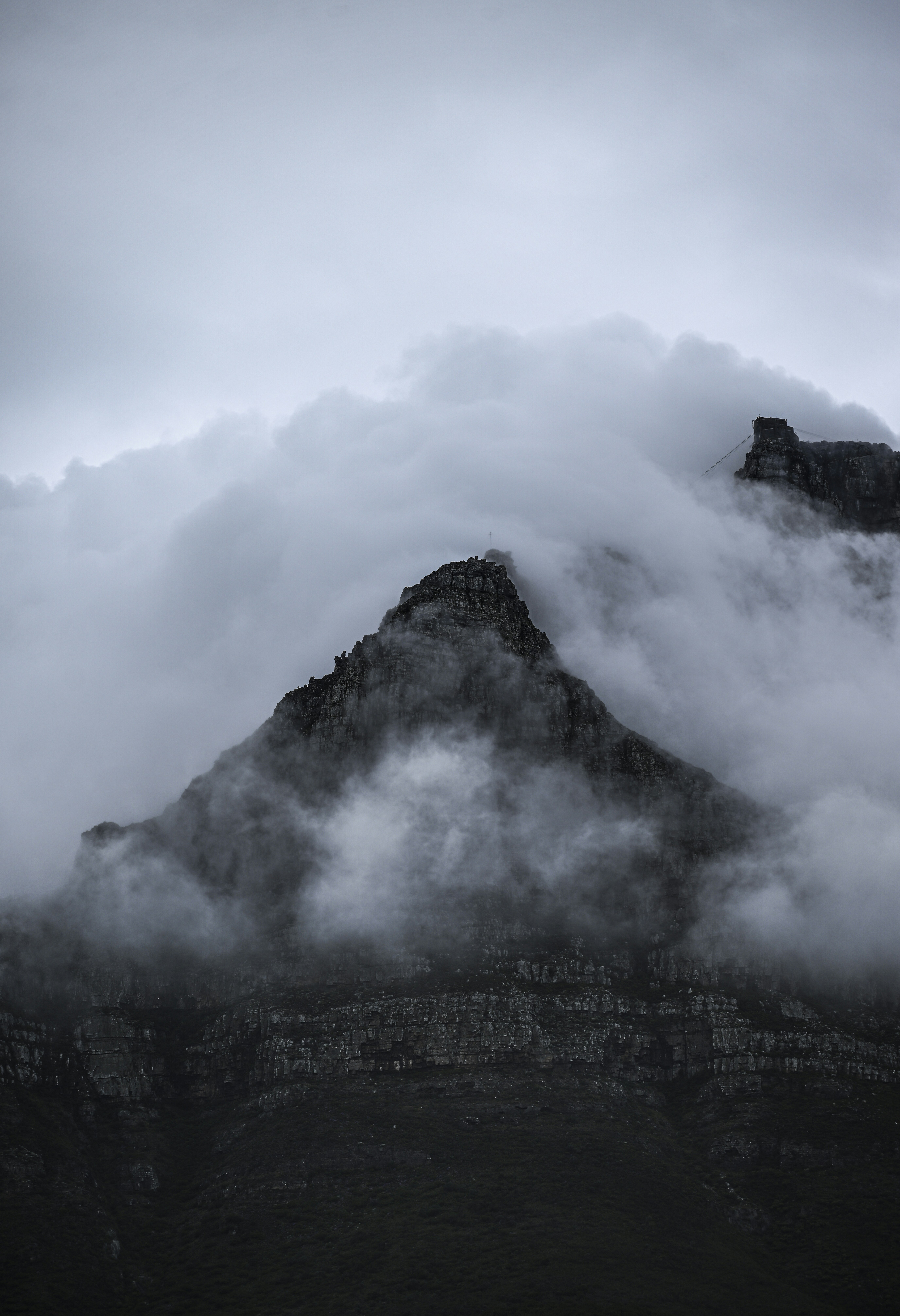 Misty clouds obscure a rugged mountain peak