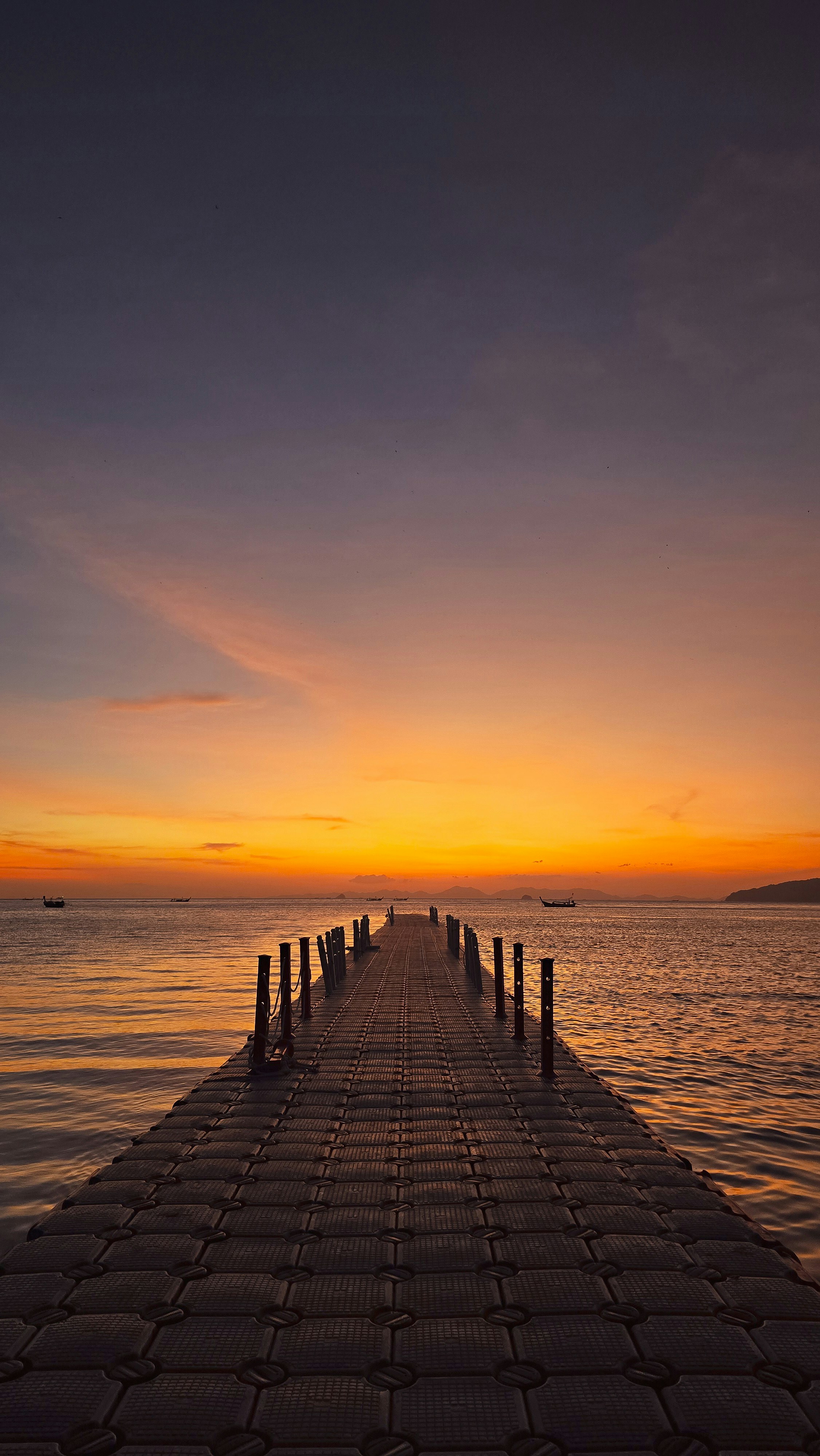 Quai s’étendant dans l’océan au coucher du soleil