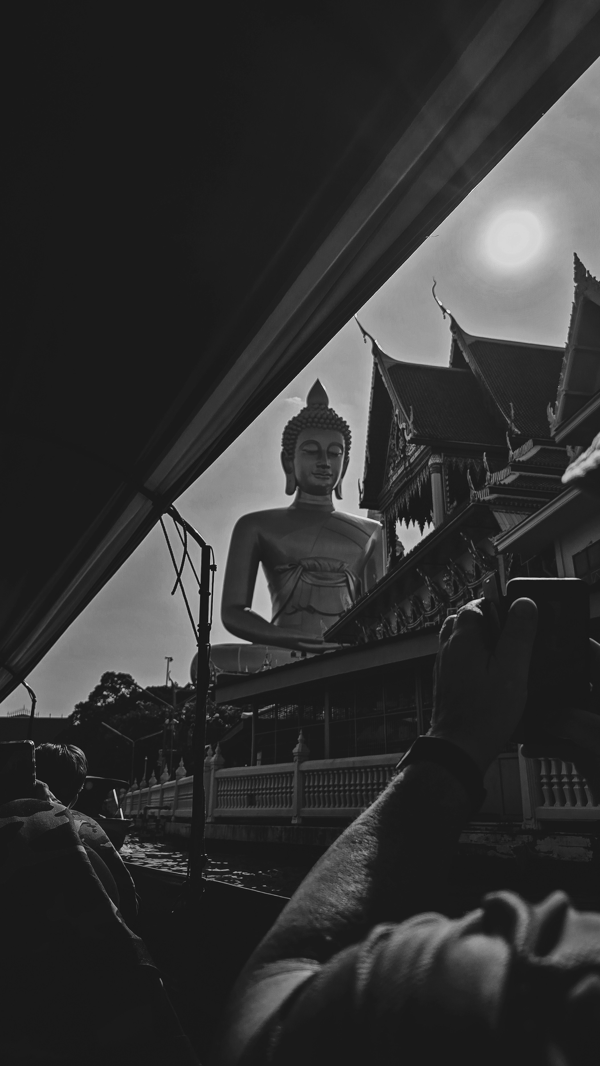 Statue géante de Bouddha contre un soleil éclatant et un temple