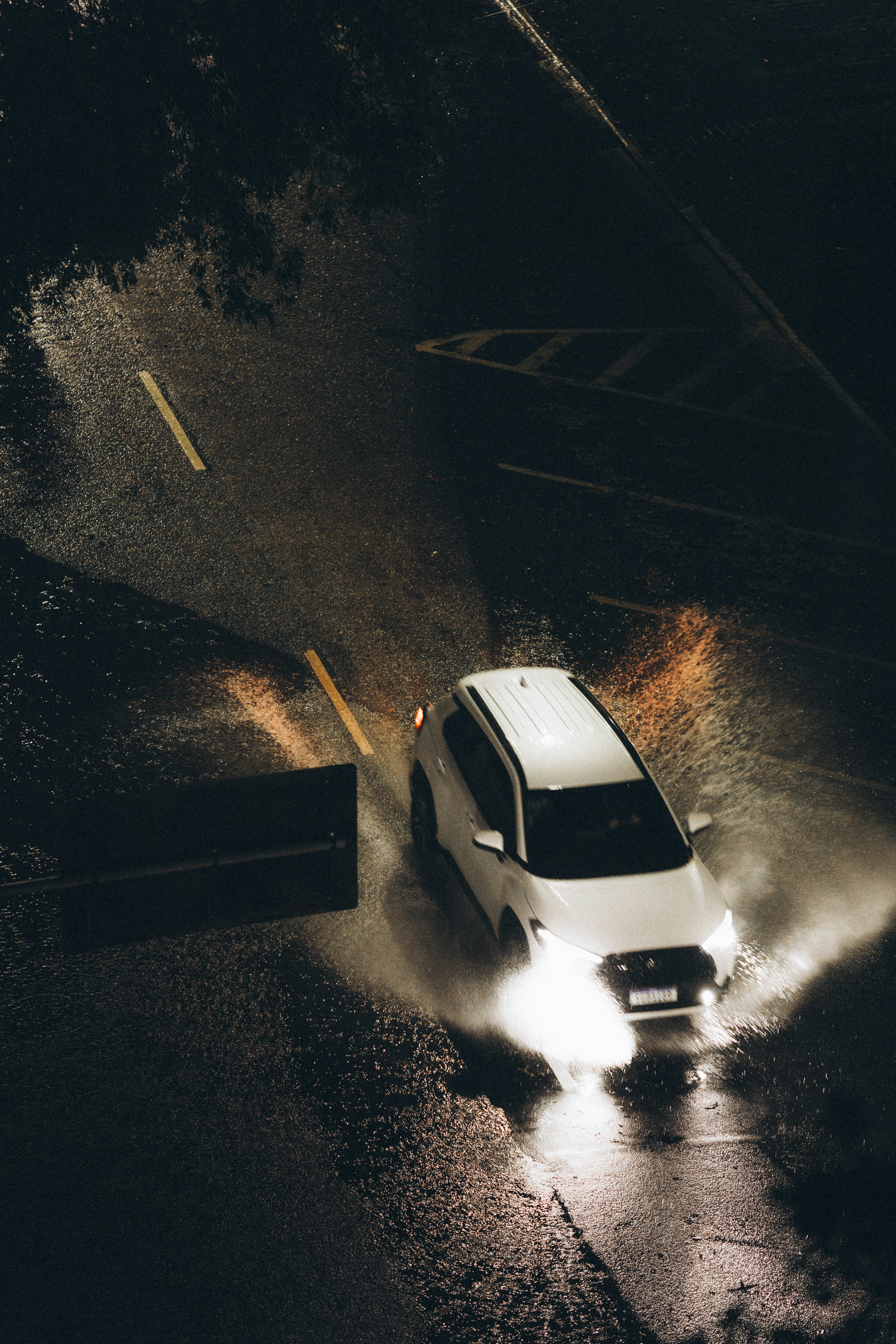 Car driving through puddles at night