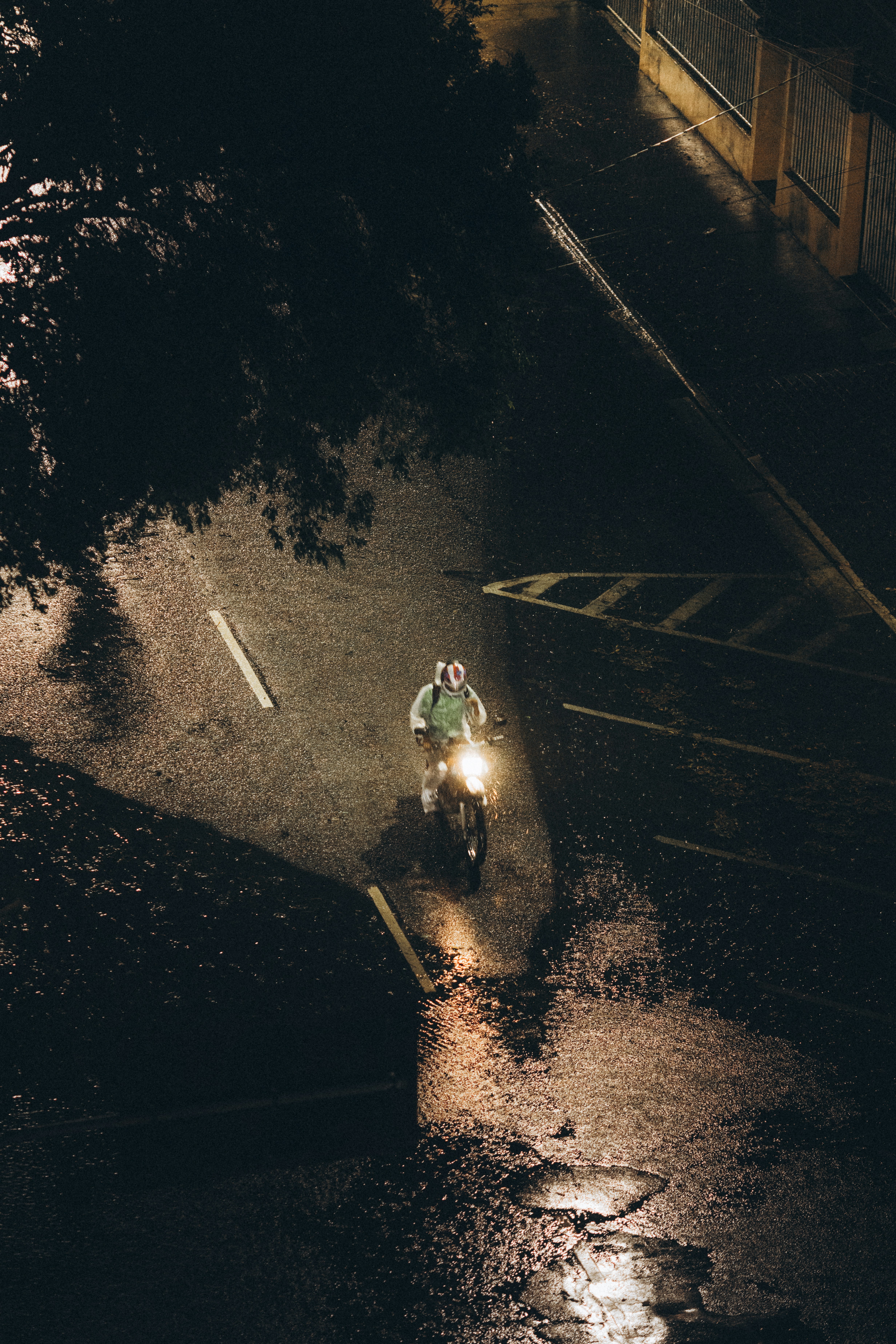 Motorcyclist rides on wet street at night