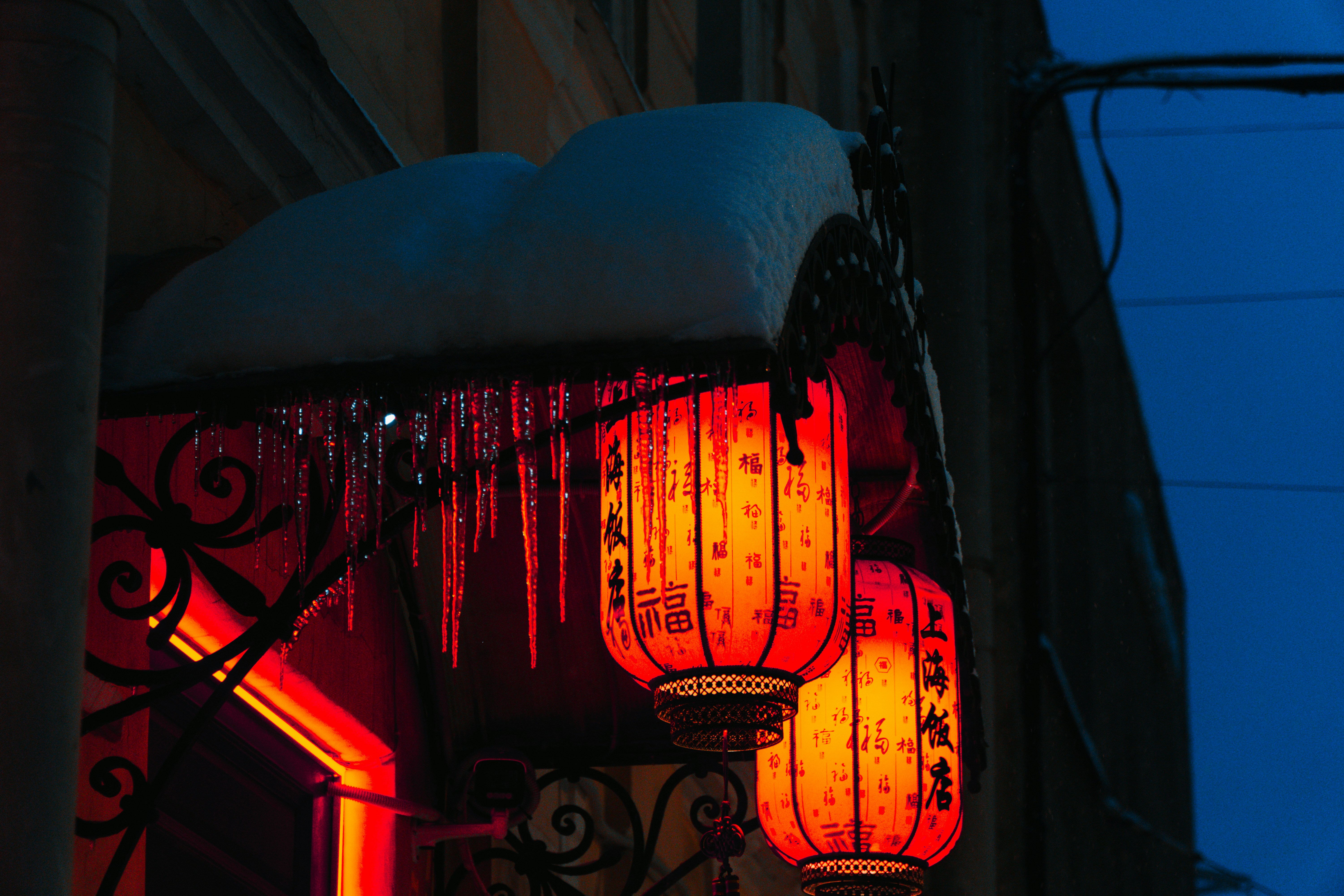 Deux lanternes rouges illuminées sont suspendues à des stalactites.