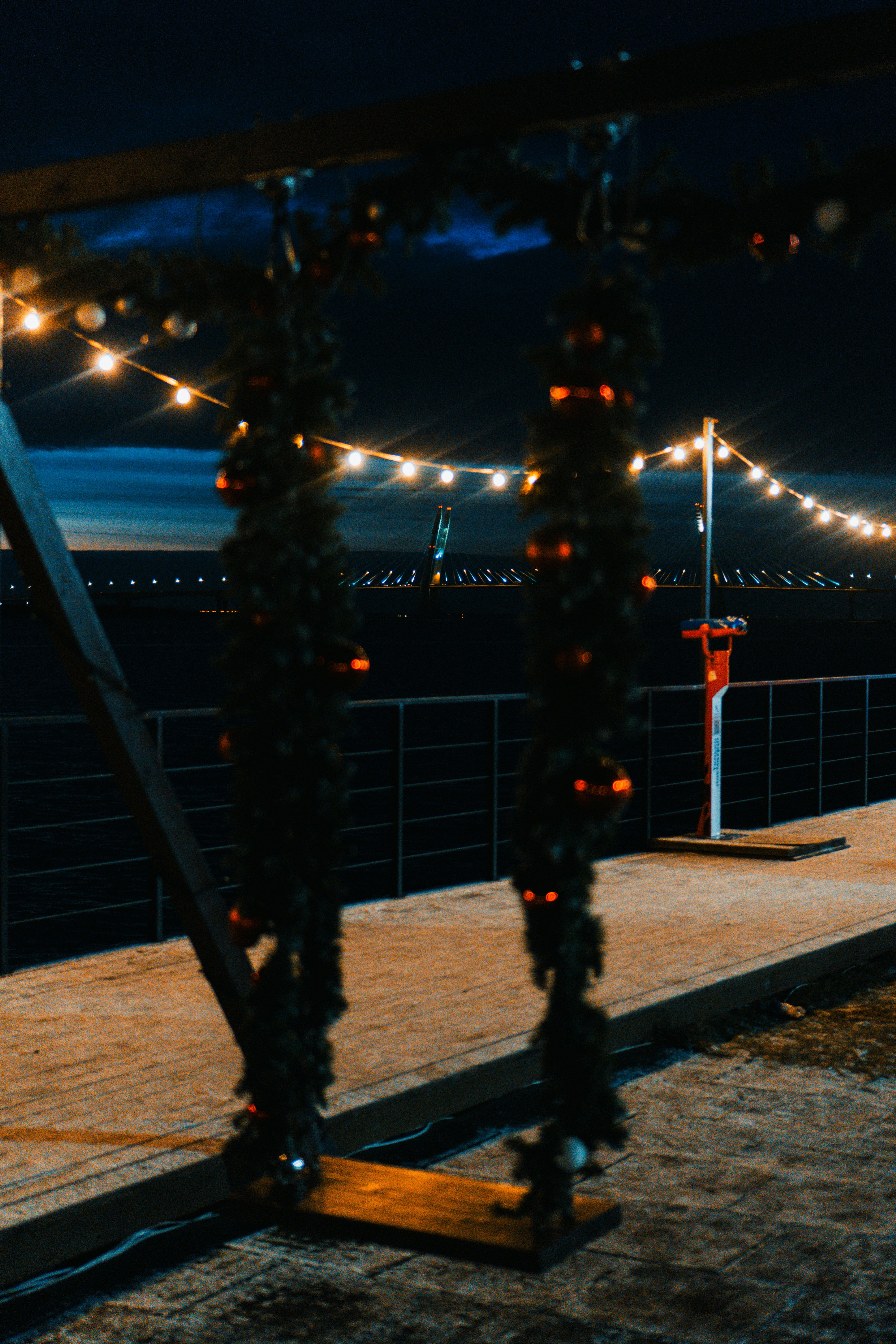 Une balançoire décorée la nuit avec des guirlandes lumineuses.