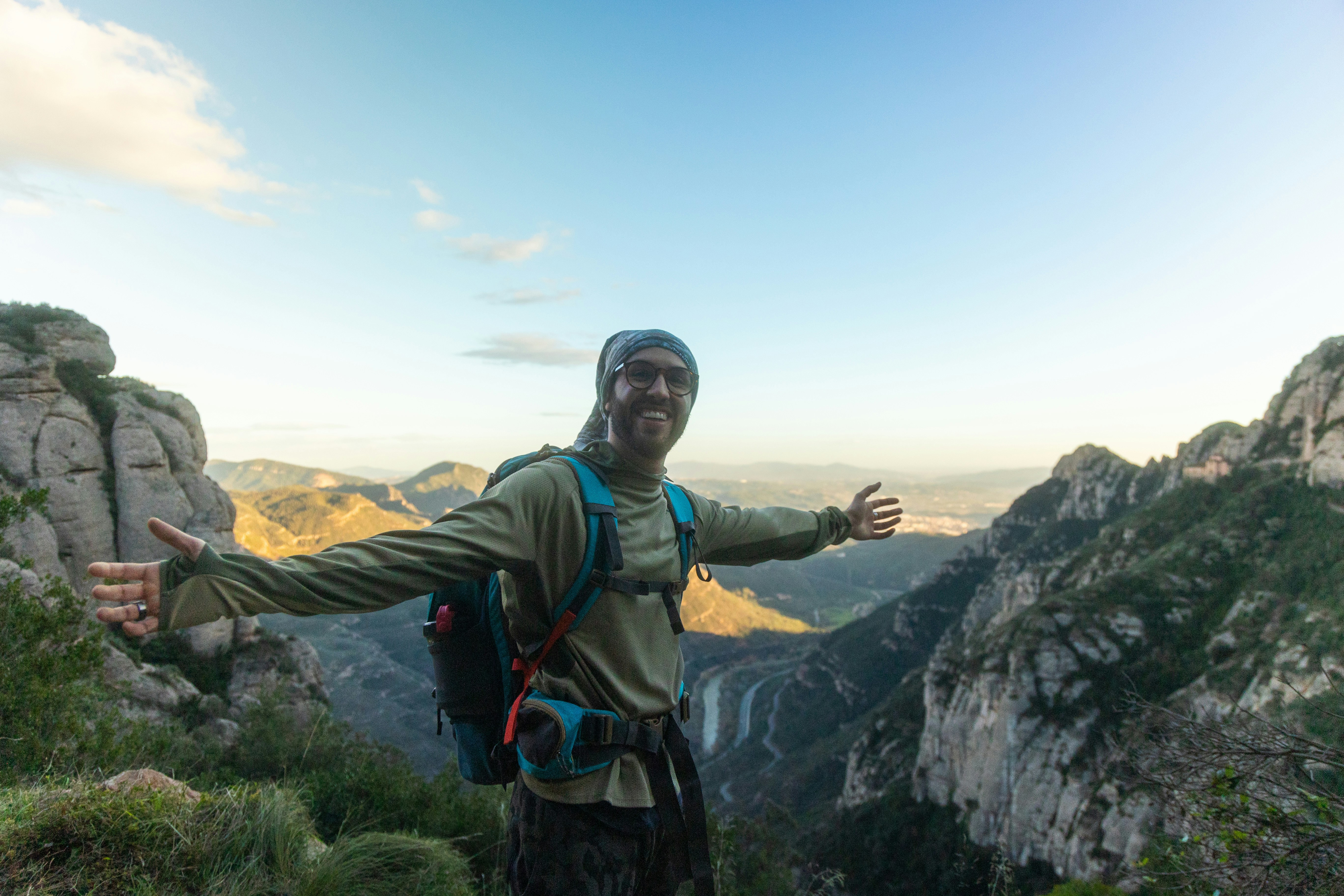 Mann mit ausgestreckten Armen auf dem Berggipfel