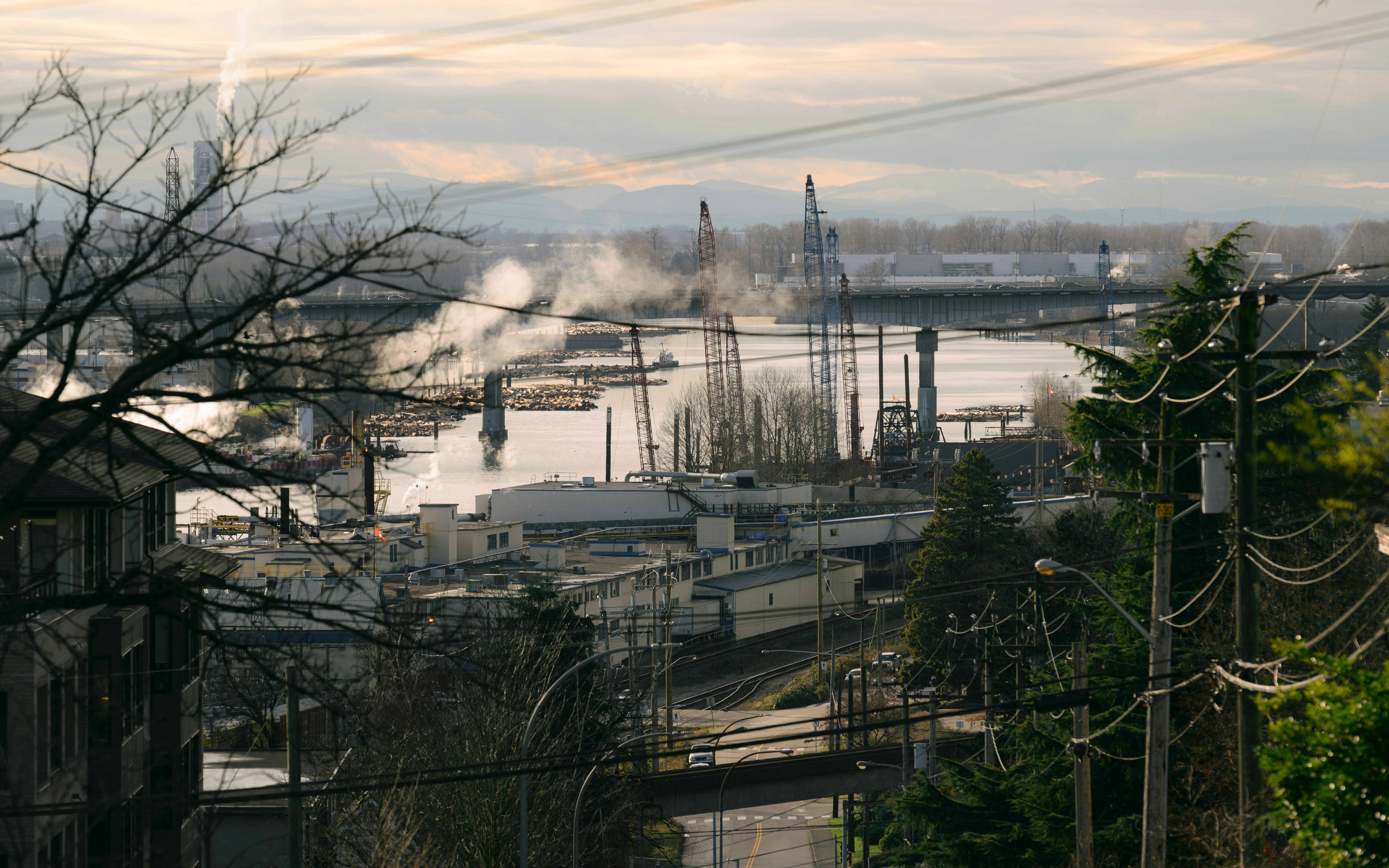 Frente marítimo industrial con chimeneas y grúas.