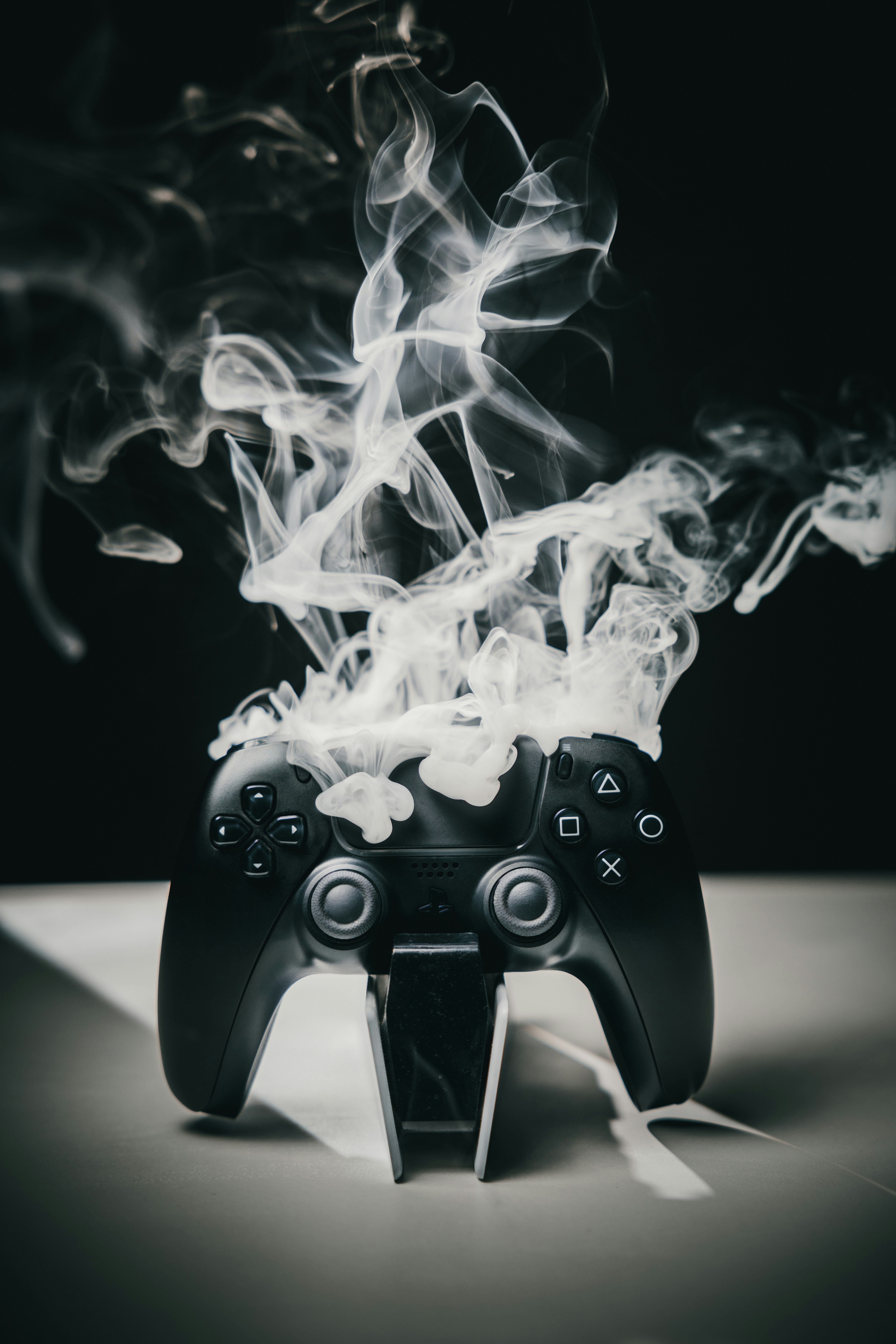 Ein schwarzer Videospielcontroller, der Rauch abgibt