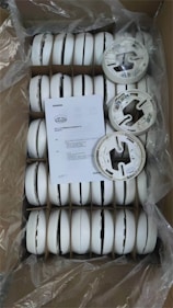 Box of new white smoke detectors with instructions.