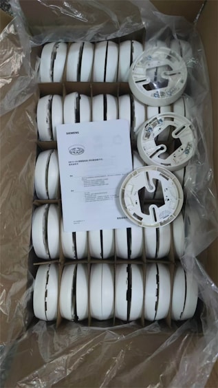 Box of new white smoke detectors with instructions.