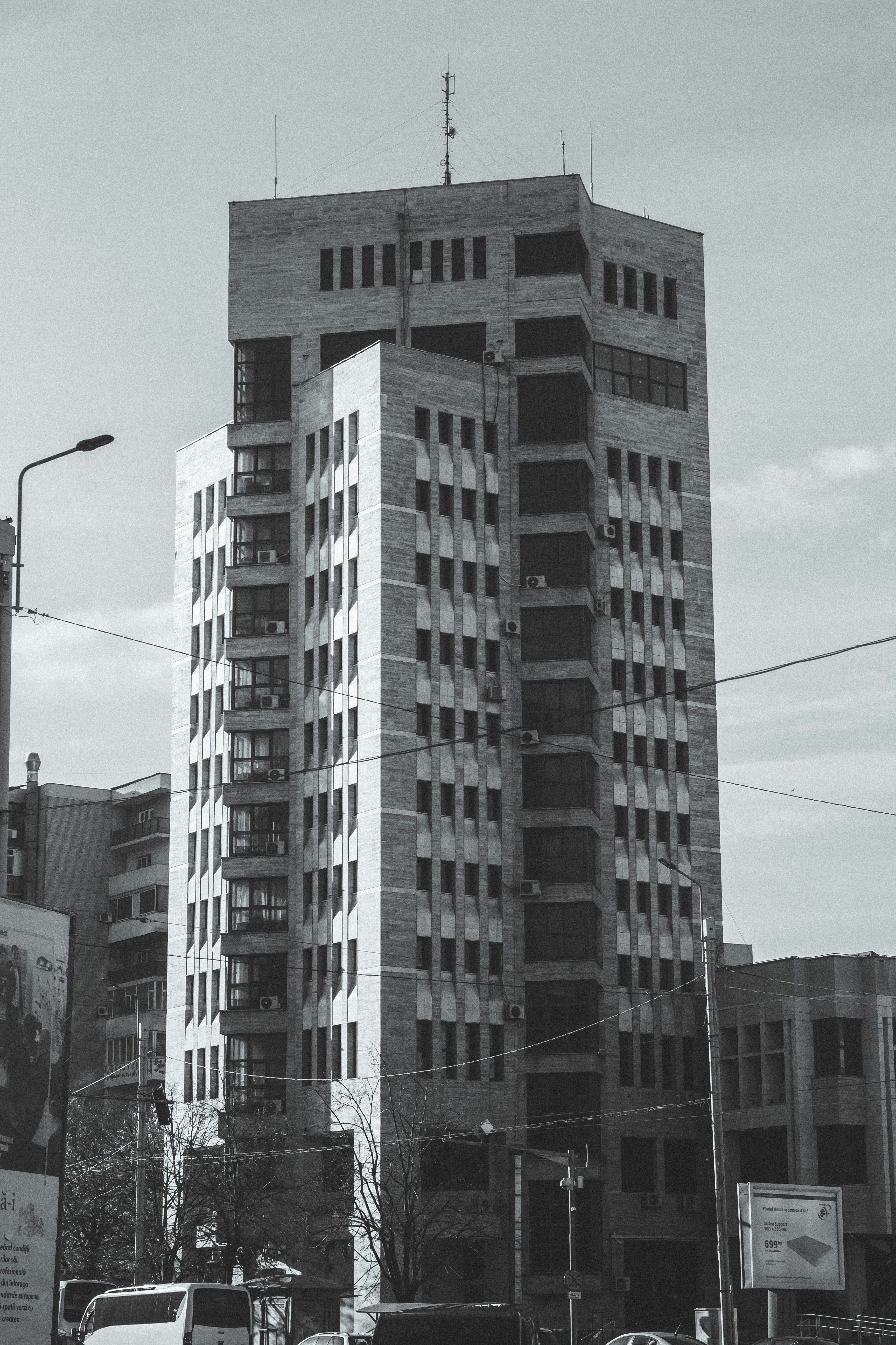 Tall brutalist building with many windows and balconies.