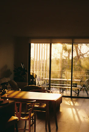 Sunlight streams into a dining area with a table.
