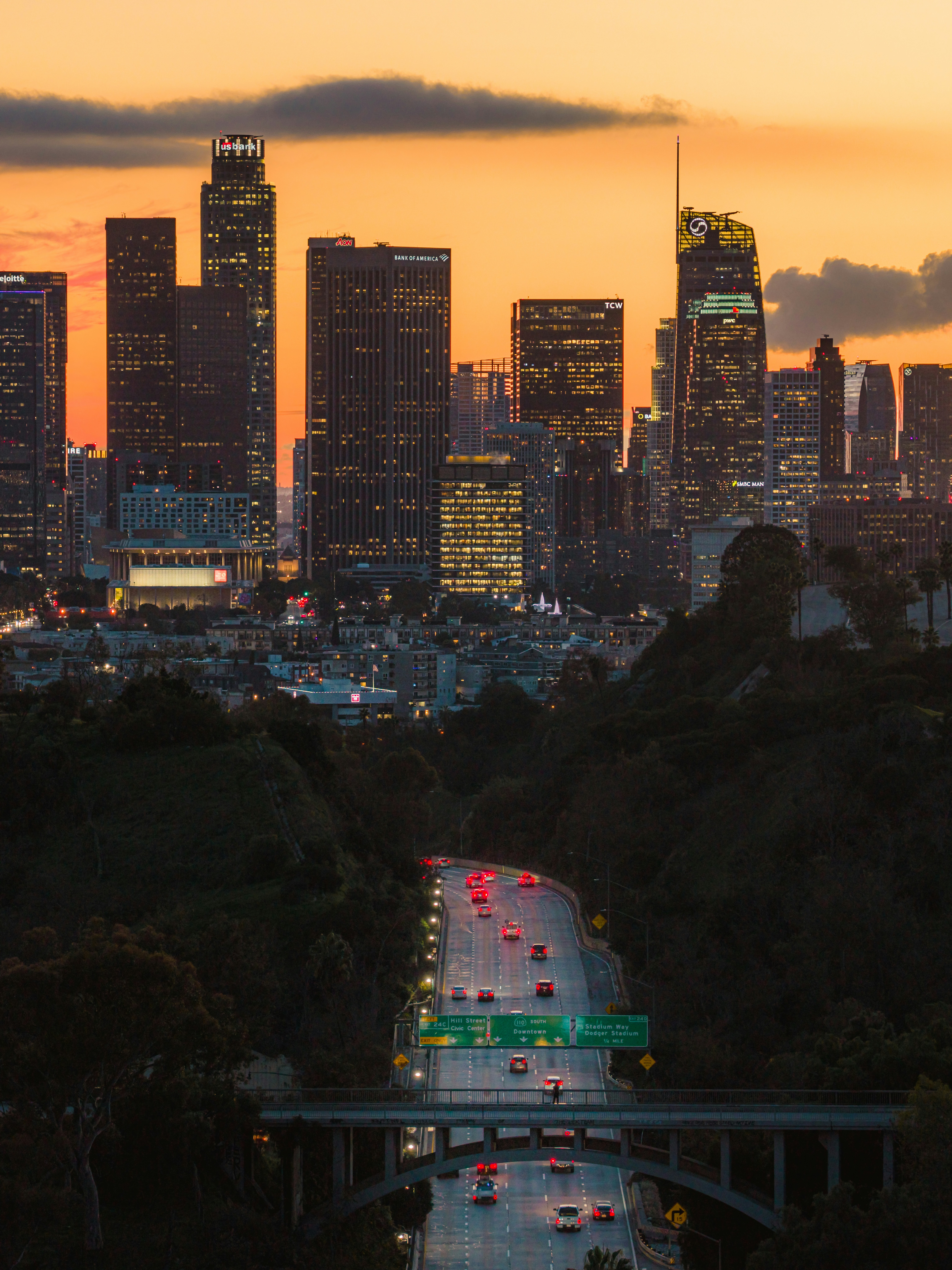 City skyline at dusk with highway traffic below.