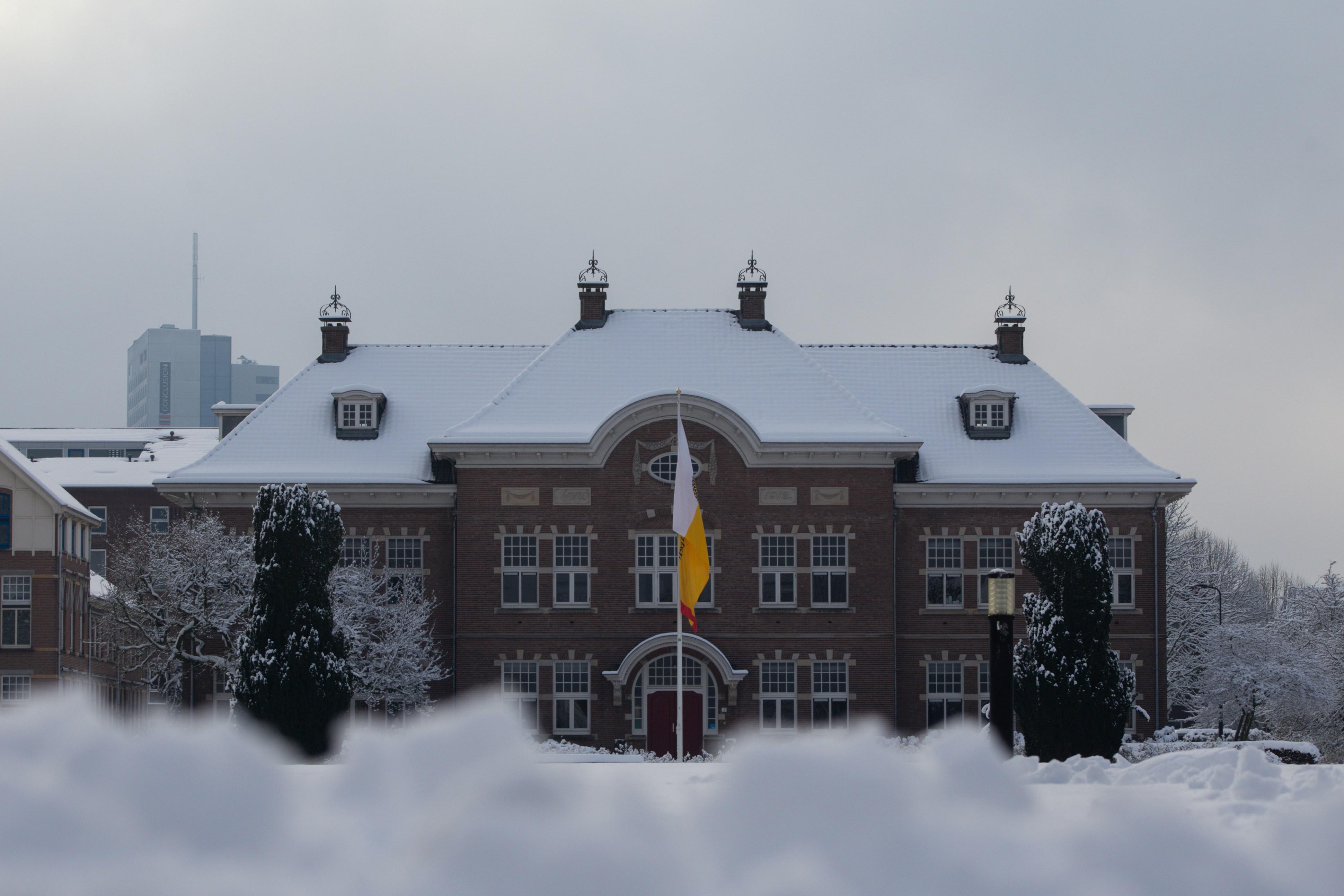 Snow-covered building with a flag in front.