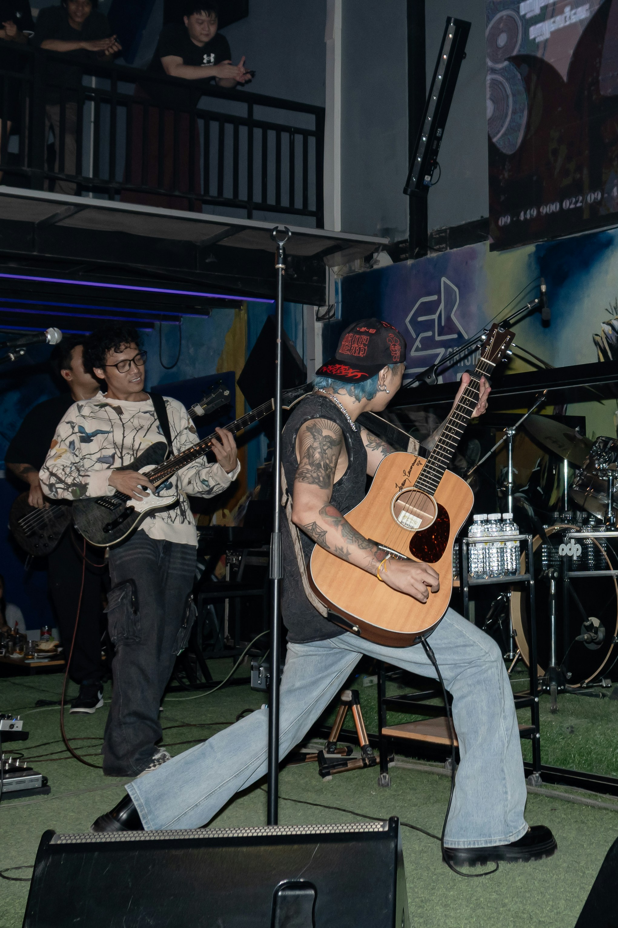 Band performing live music on stage with guitars.