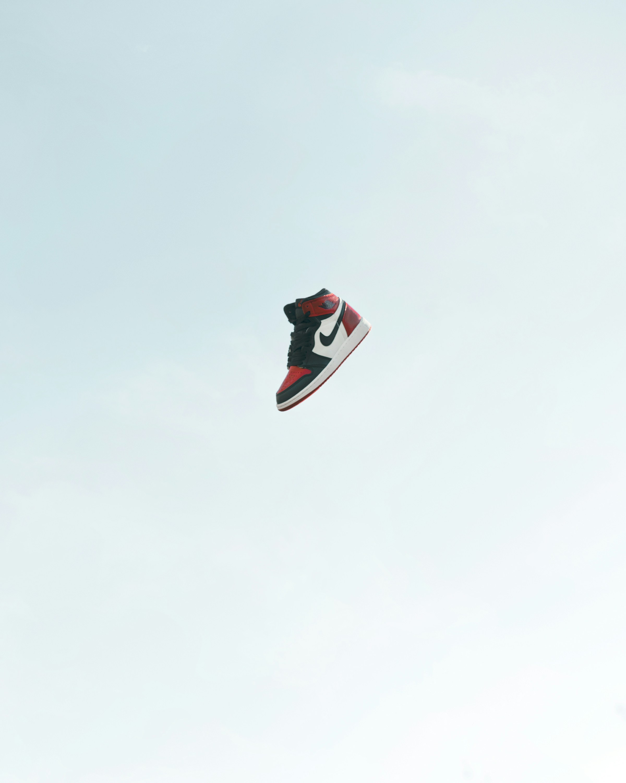 A single sneaker suspended in a clear sky