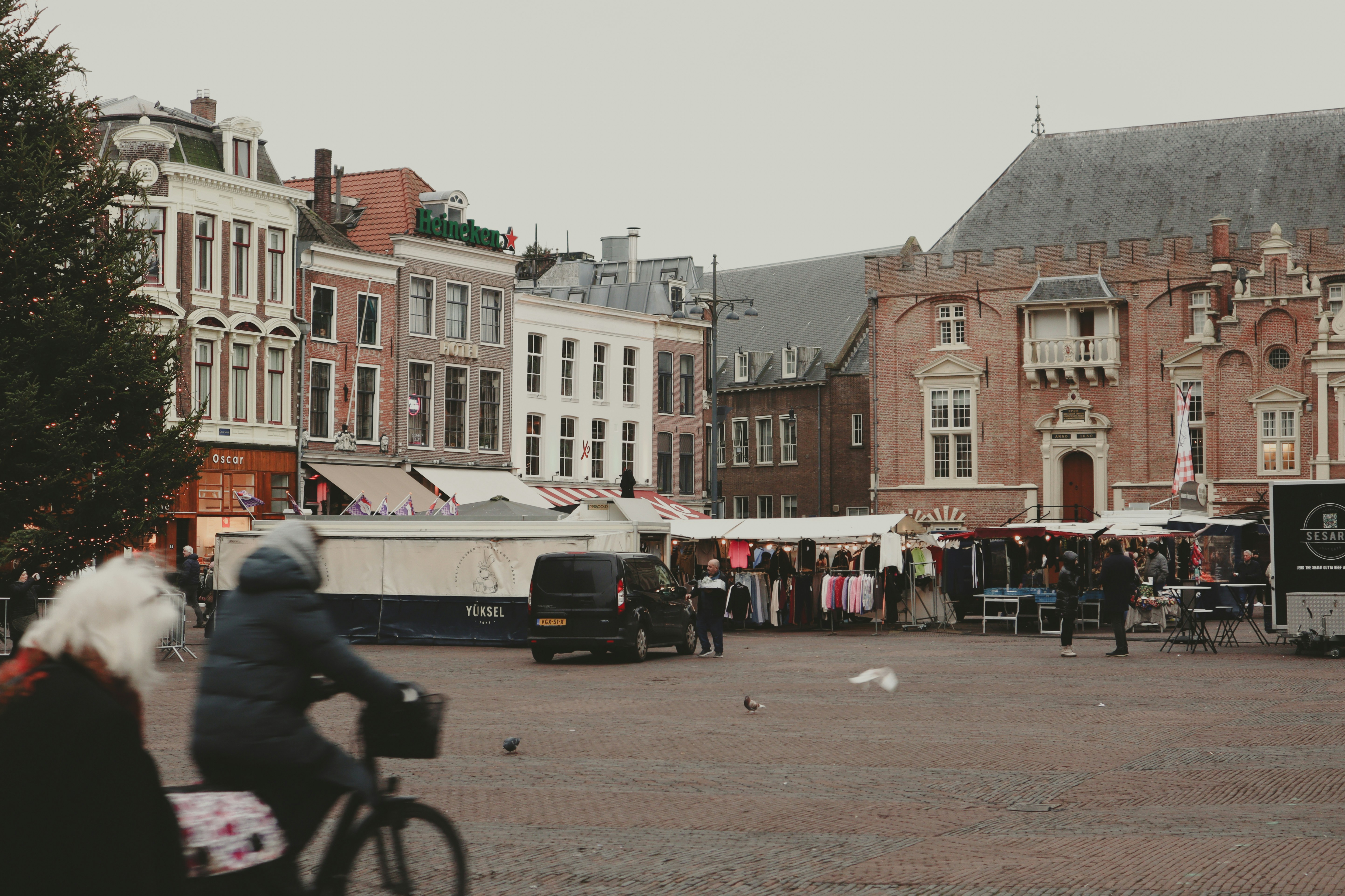 People at an outdoor market with historic buildings