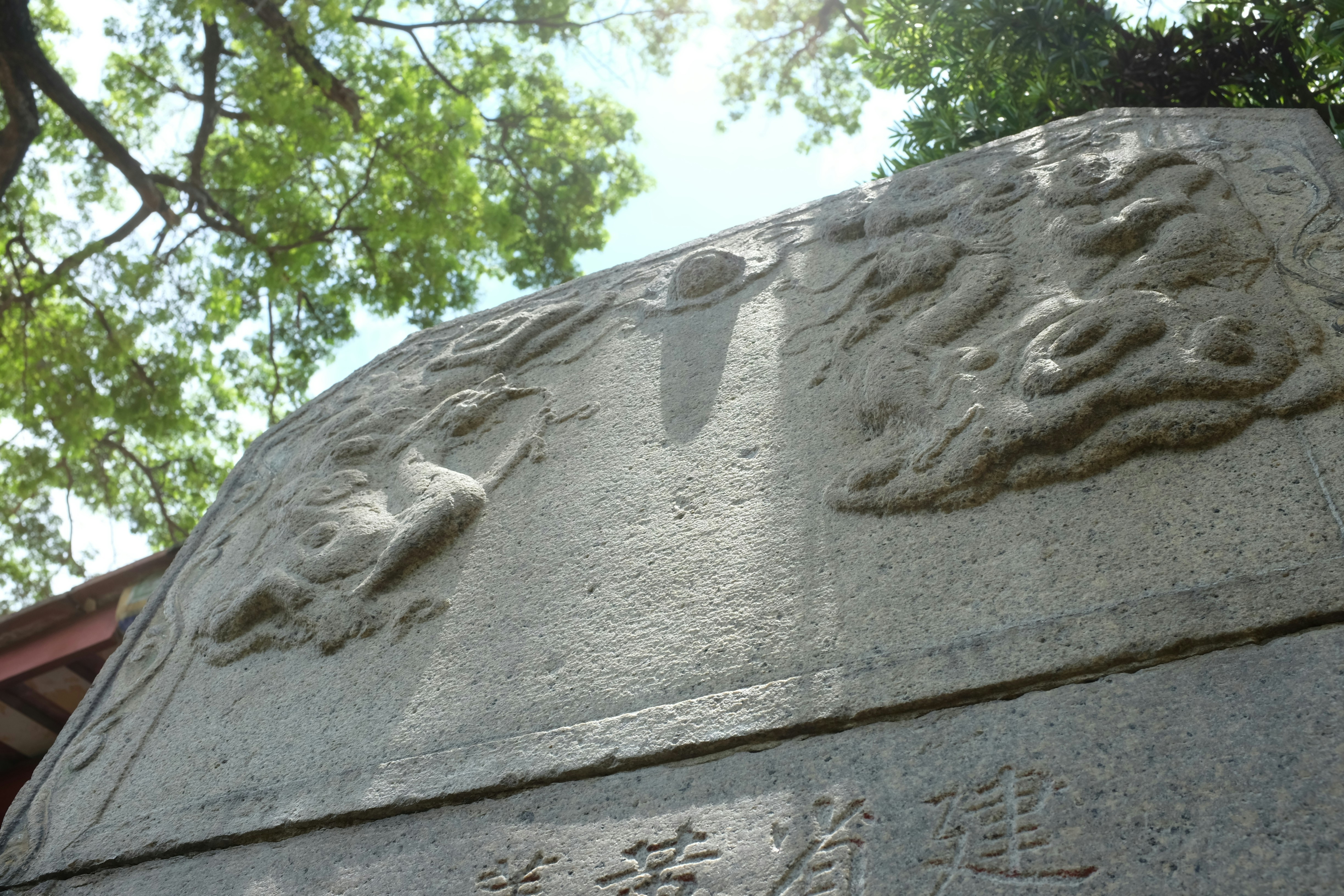 Stone monument with carved dragon motifs and chinese characters.