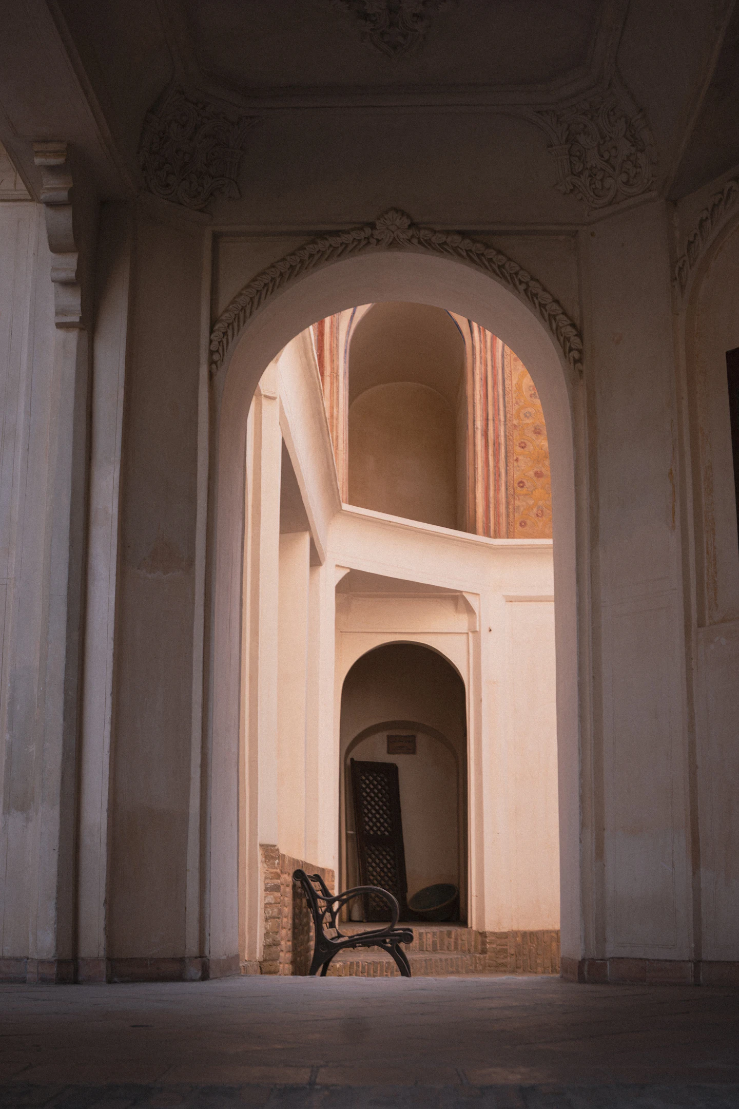 Sunlit arcade with a stone bench